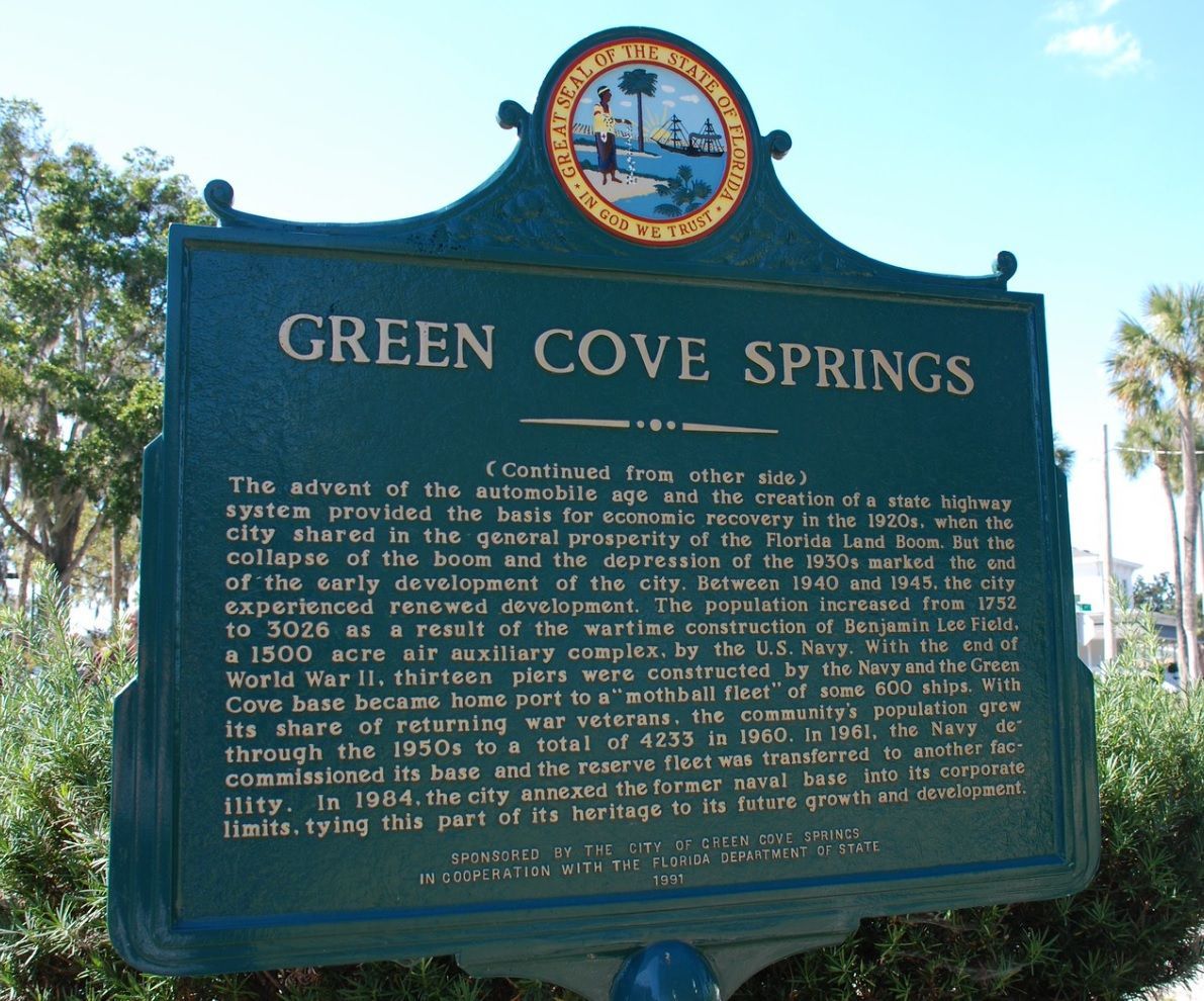 Historical marker for Green Cove Springs, Florida; dark green sign with gold lettering and emblem, outdoors.