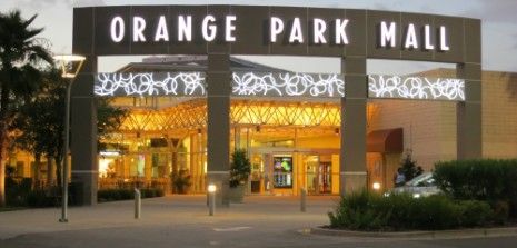 Orange Park Mall entrance at dusk with lit signage.