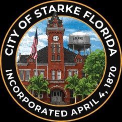 Person installing pink fiberglass insulation in a wooden wall frame.