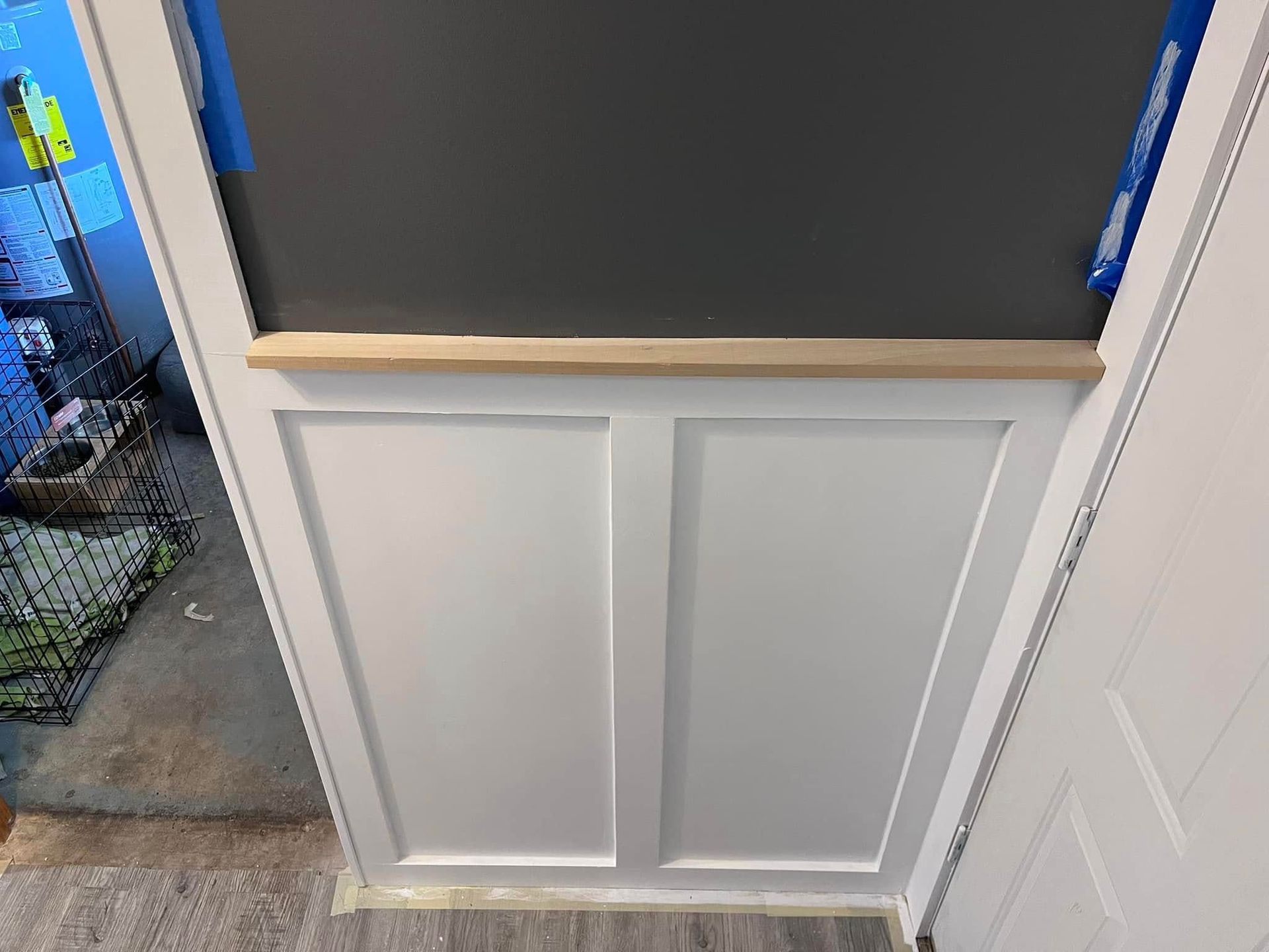 A white door with a chalkboard on top of it.