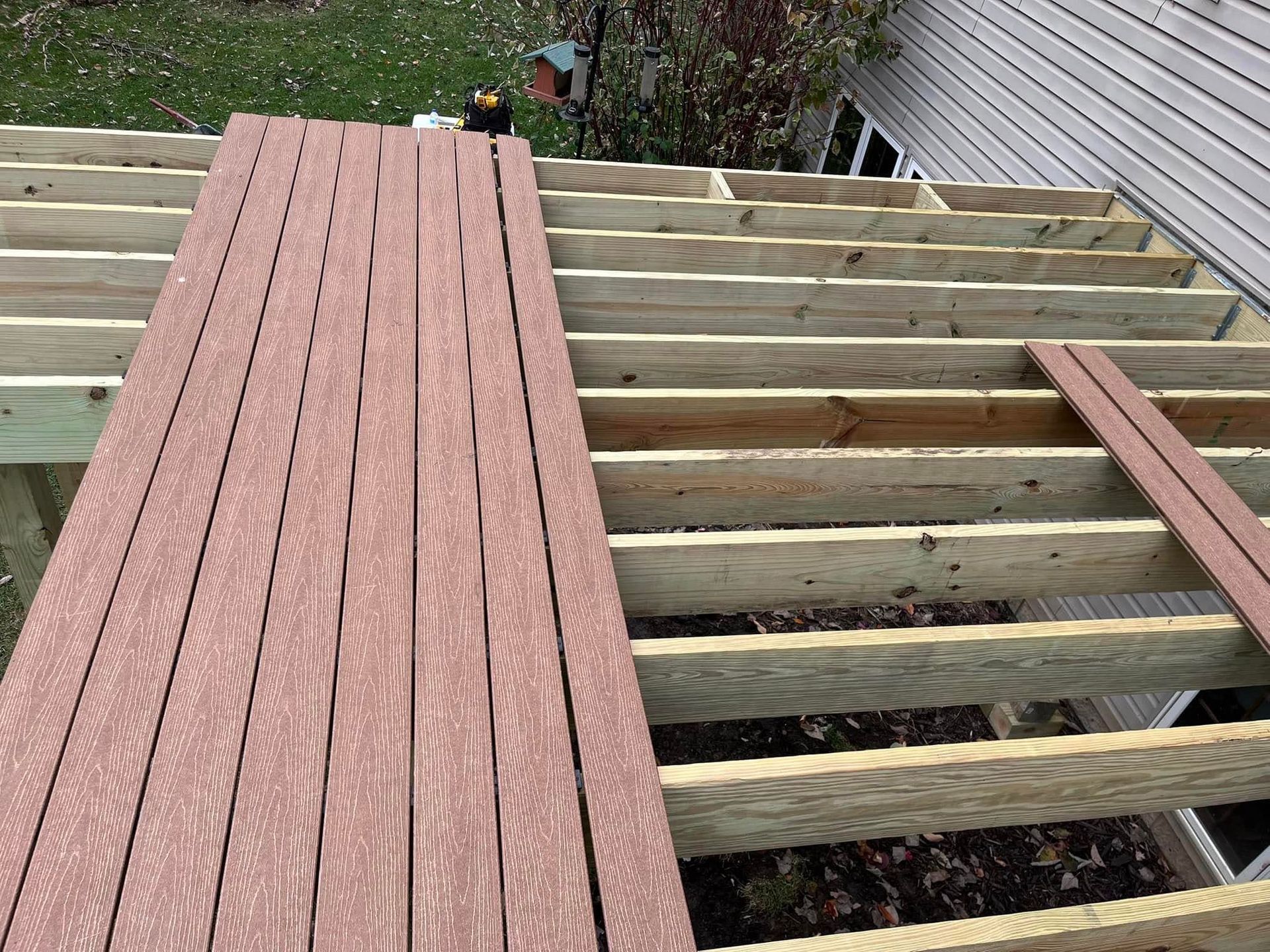 A wooden deck is being built on top of a house.
