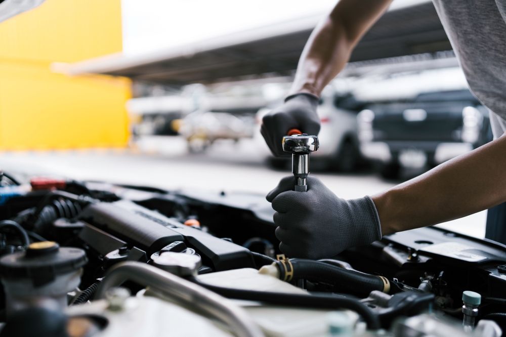 Mechanic Using a Wrench on a Car Engine, Wearing Gloves, Outdoors — All Auto & Mechanical in Gosford, NSW