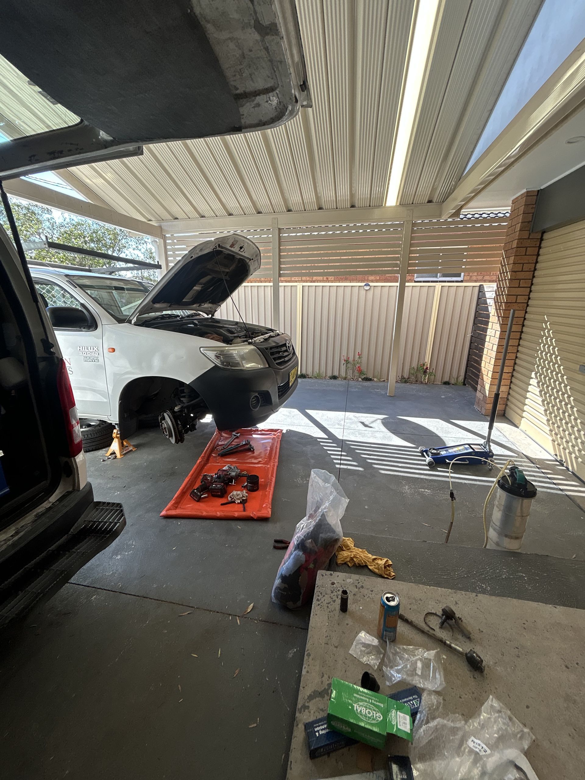 Car being worked on in a garage with tools and parts laid out. — All Auto & Mechanical in The Entrance North, NSW