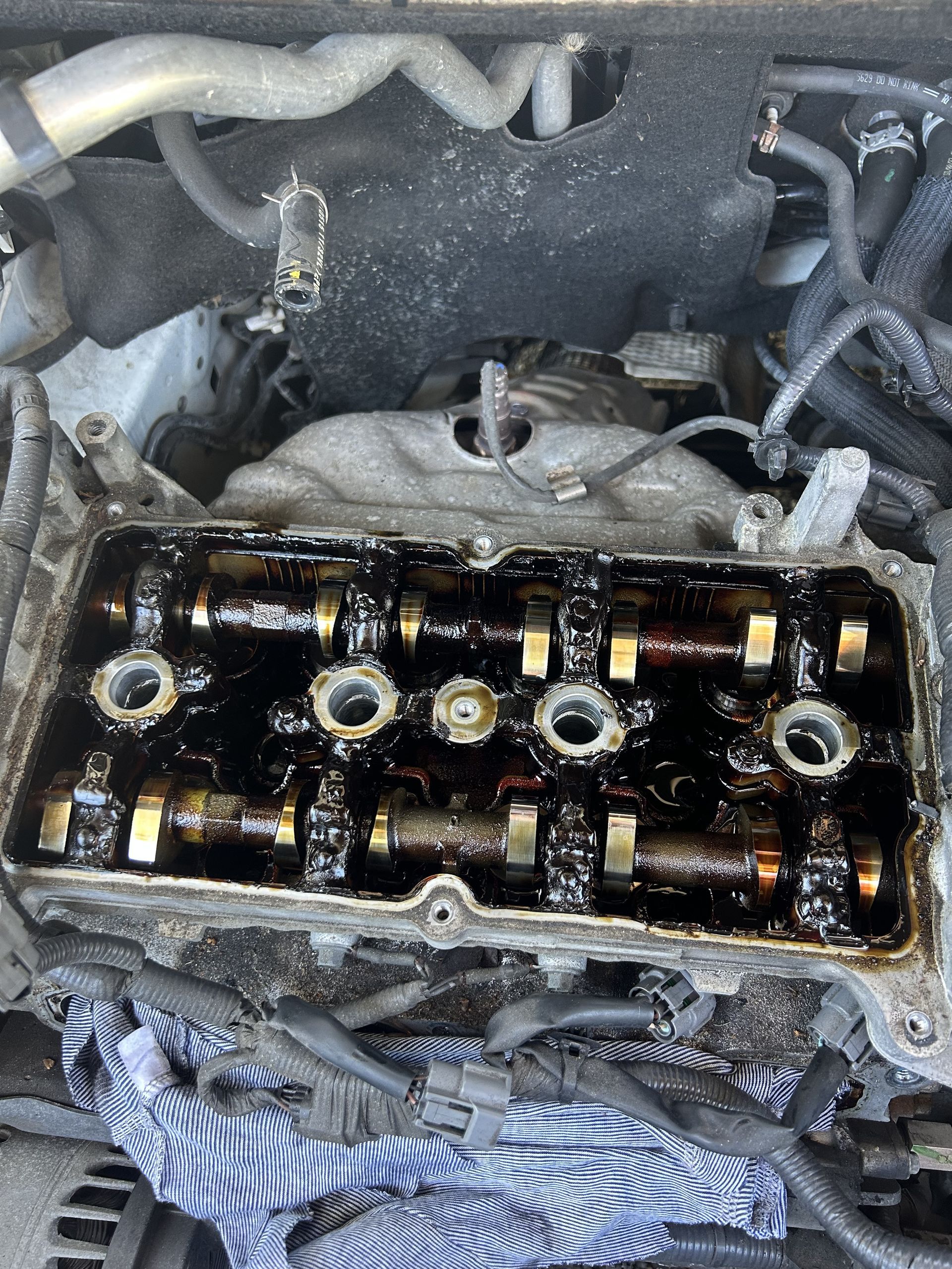 Open car engine showing oily camshafts and rocker arms. — All Auto & Mechanical in Erina, NSW