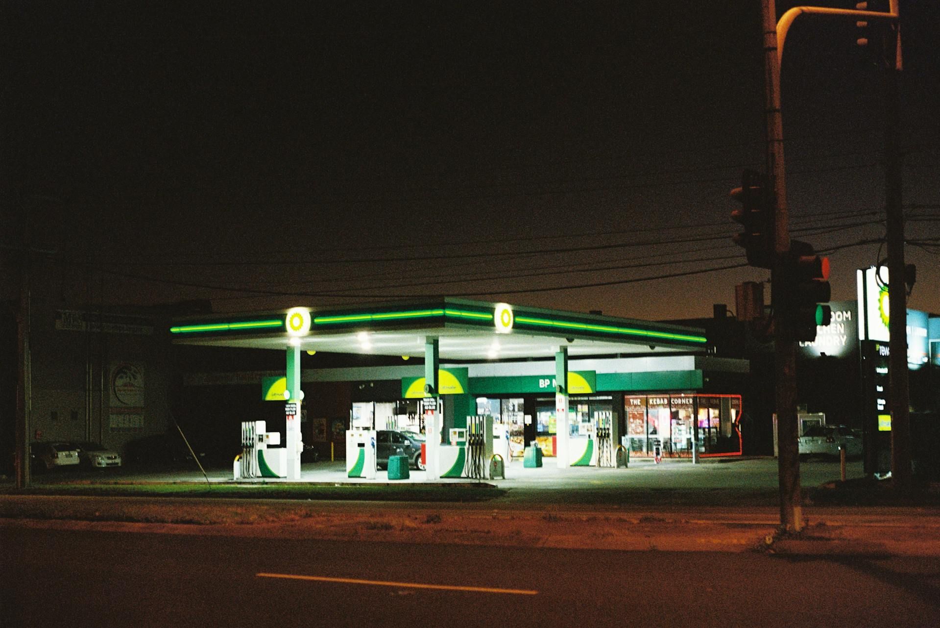 Gas station at night; green and white canopy, illuminated pumps, dark sky, road. — All Auto & Mechanical in The Entrance North, NSW