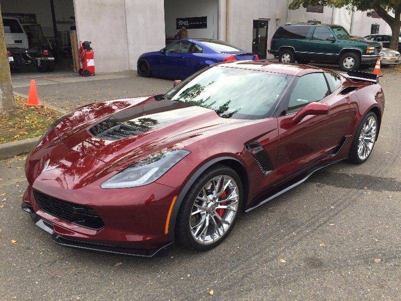 A red sports car is parked in front of a garage.