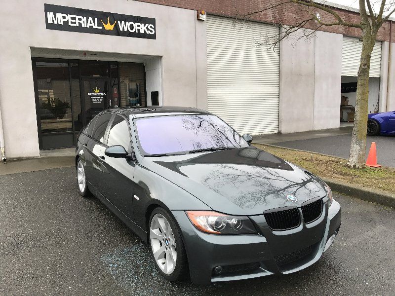 A car is parked in front of a building that says imperial works.
