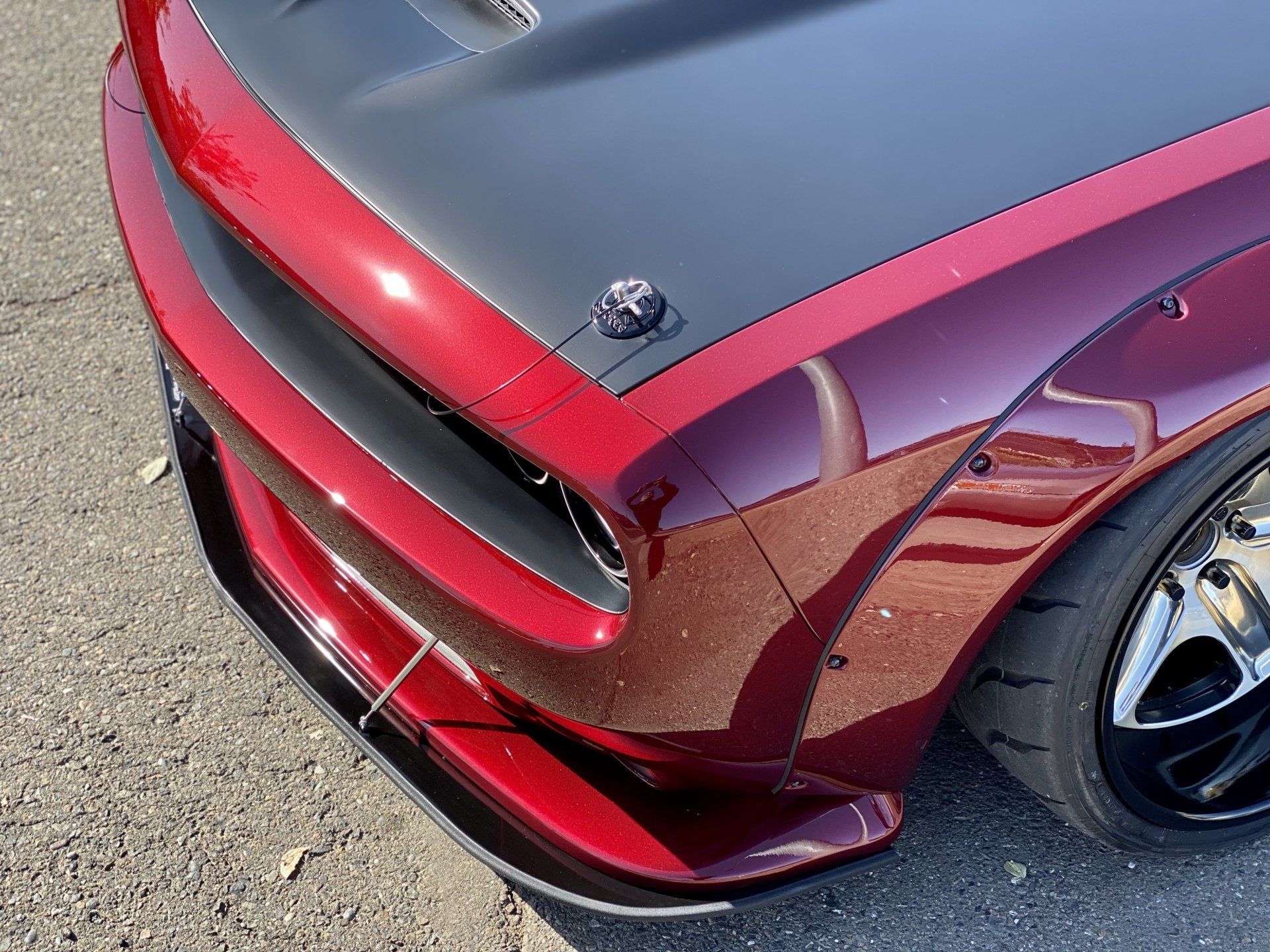 A close up of a red car with a black hood