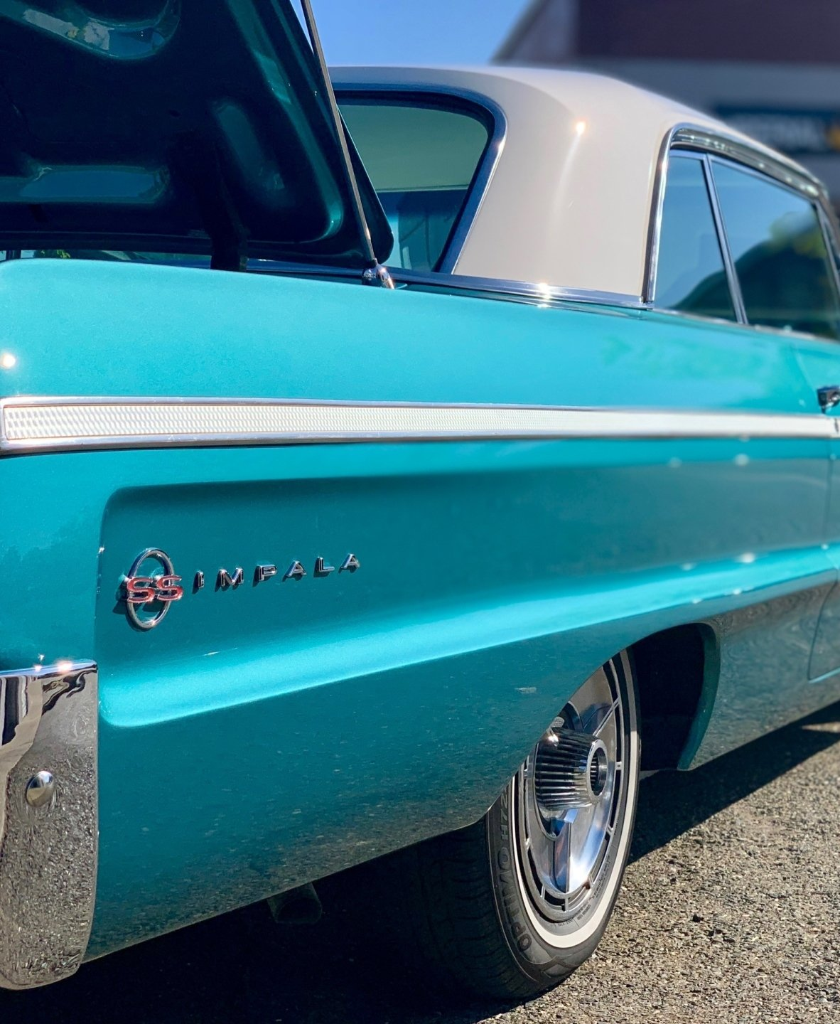 A blue impala is parked next to another car