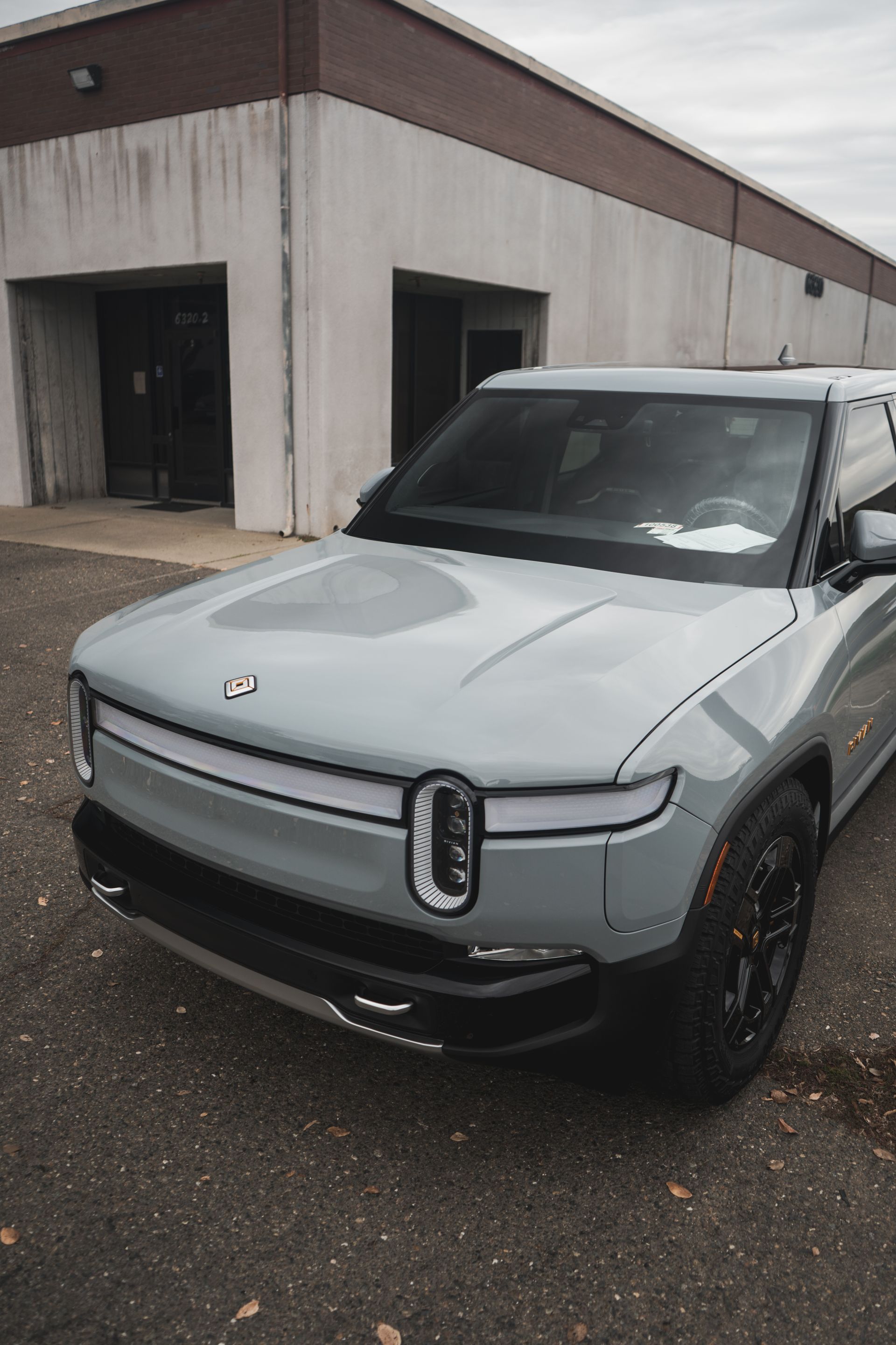 A white car is parked in front of a building.