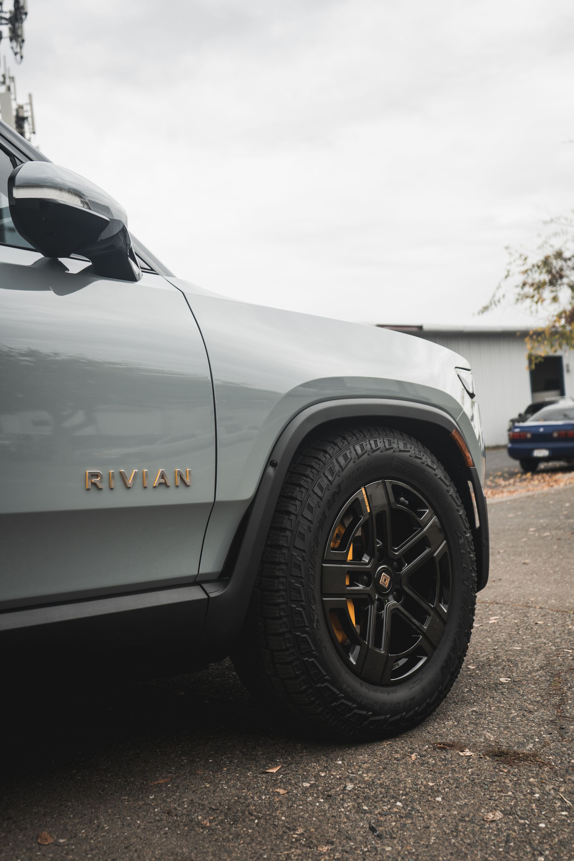 A gray suv with black wheels is parked in a parking lot.