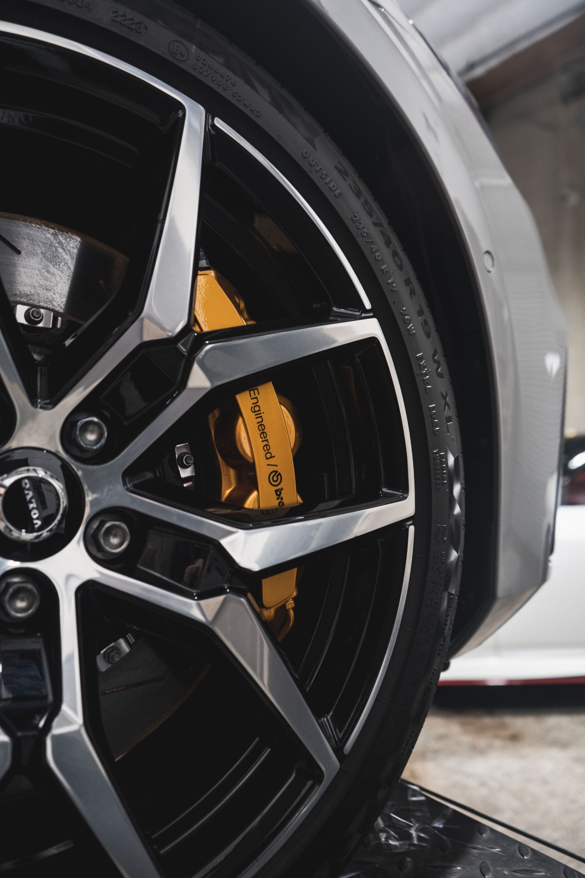 A close up of a car wheel with a yellow brembo brake caliper.