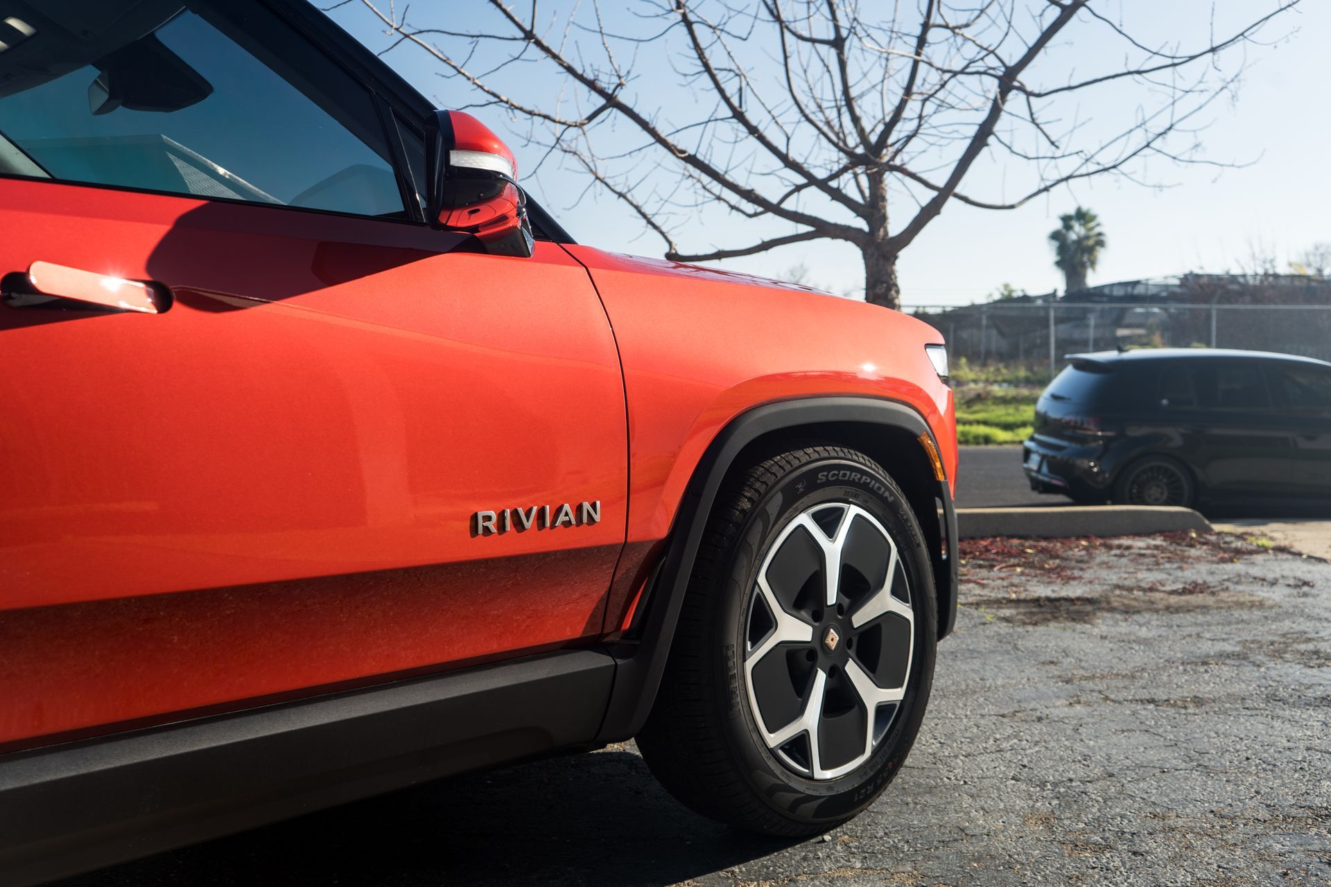 A red suv is parked in a parking lot next to a black van.