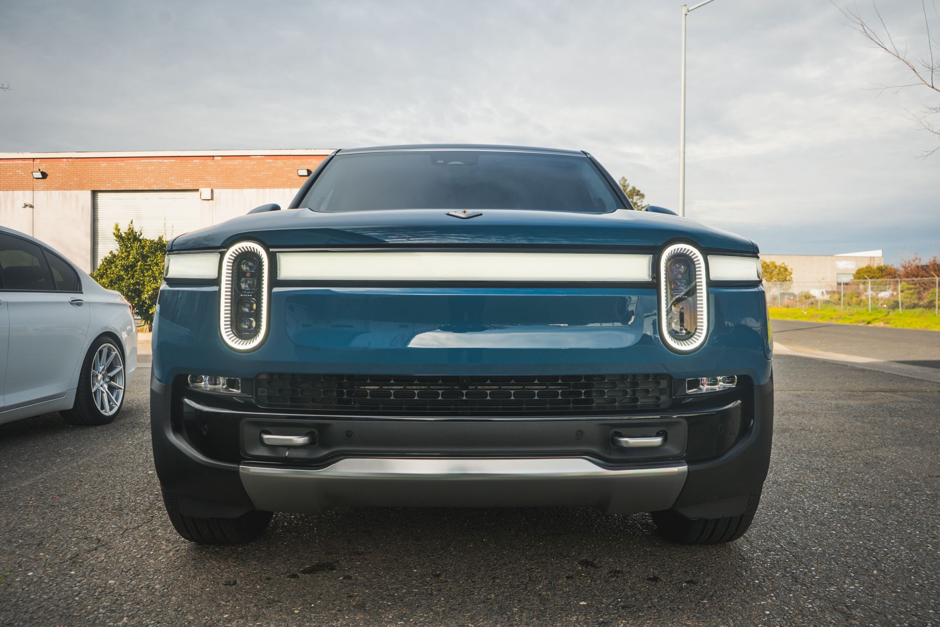 A blue car is parked in a parking lot next to a white car.