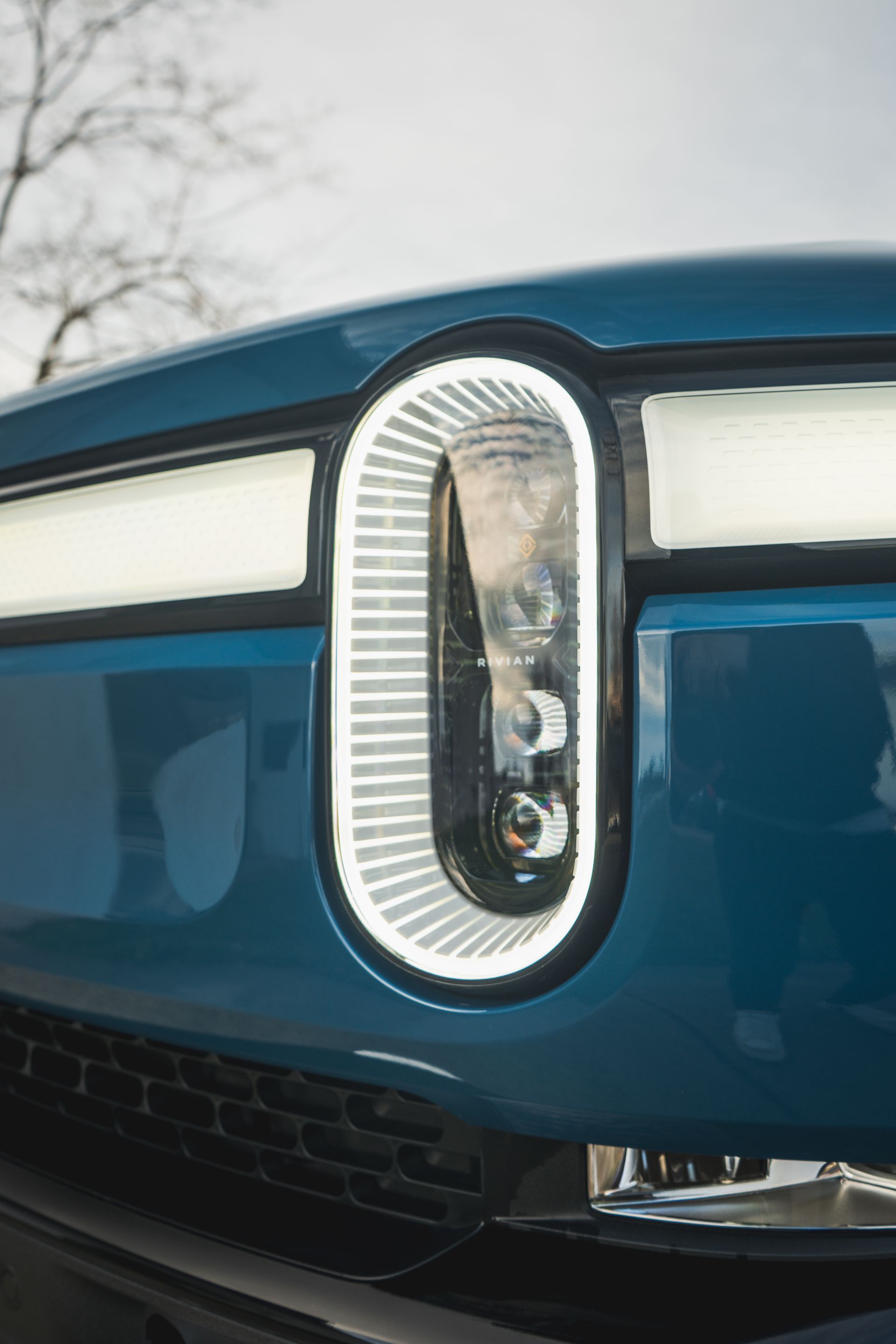 A close up of a blue car 's headlight.