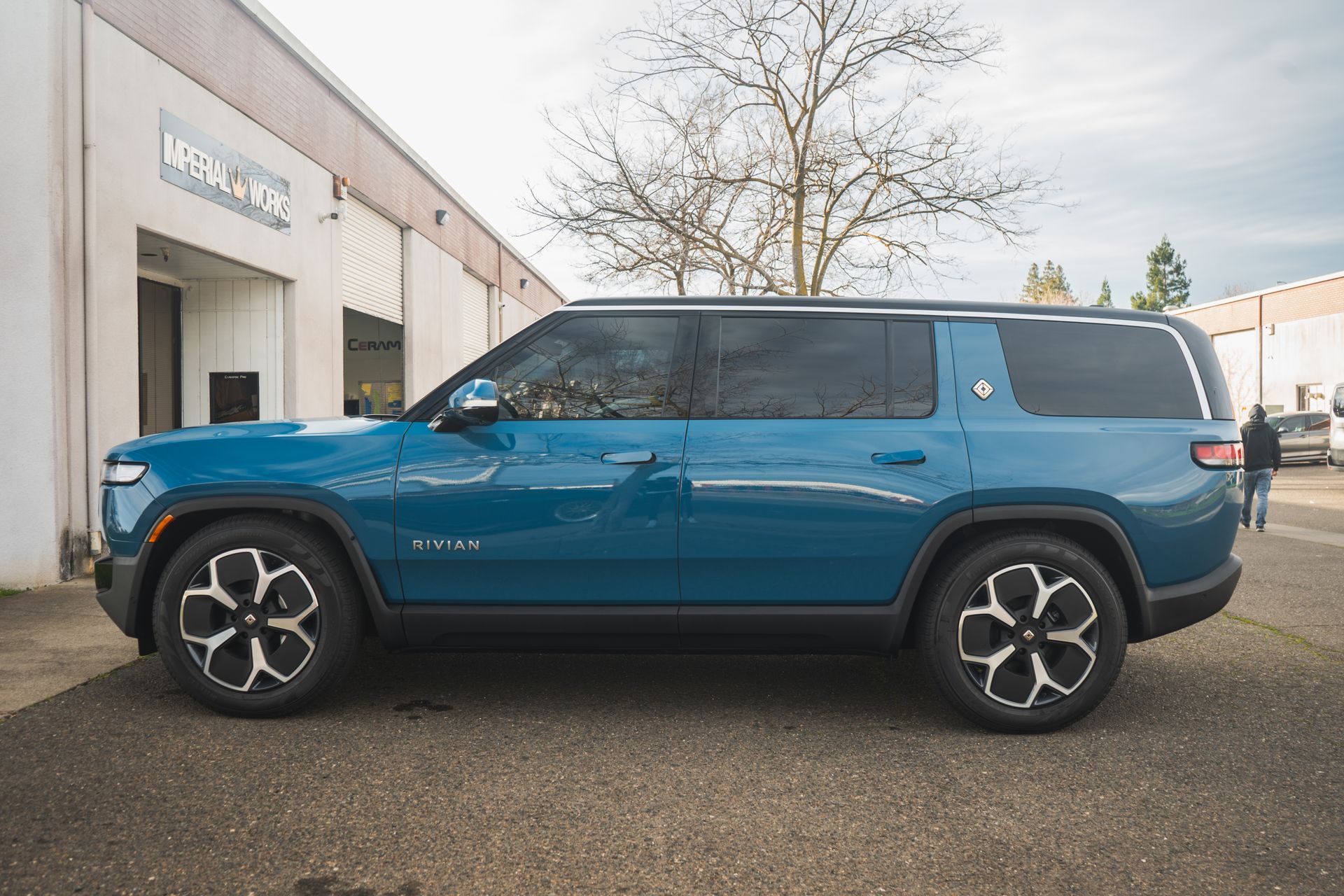 A blue suv is parked in front of a building.