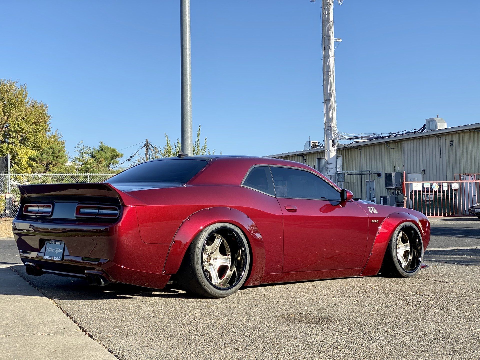 A red dodge challenger is parked on the side of the road.