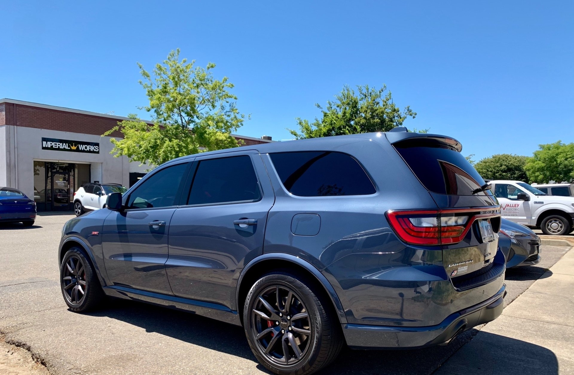 A gray dodge durango is parked in a parking lot.