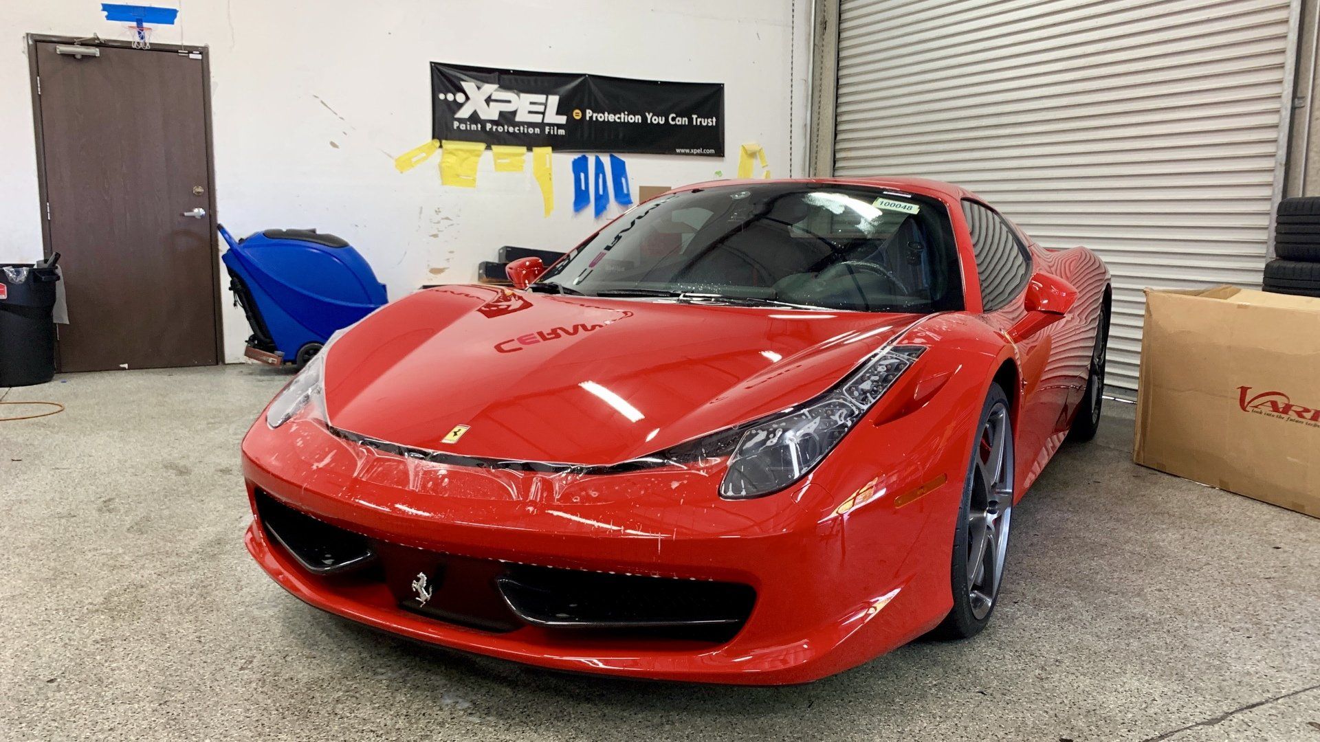 A red sports car is parked in a garage.