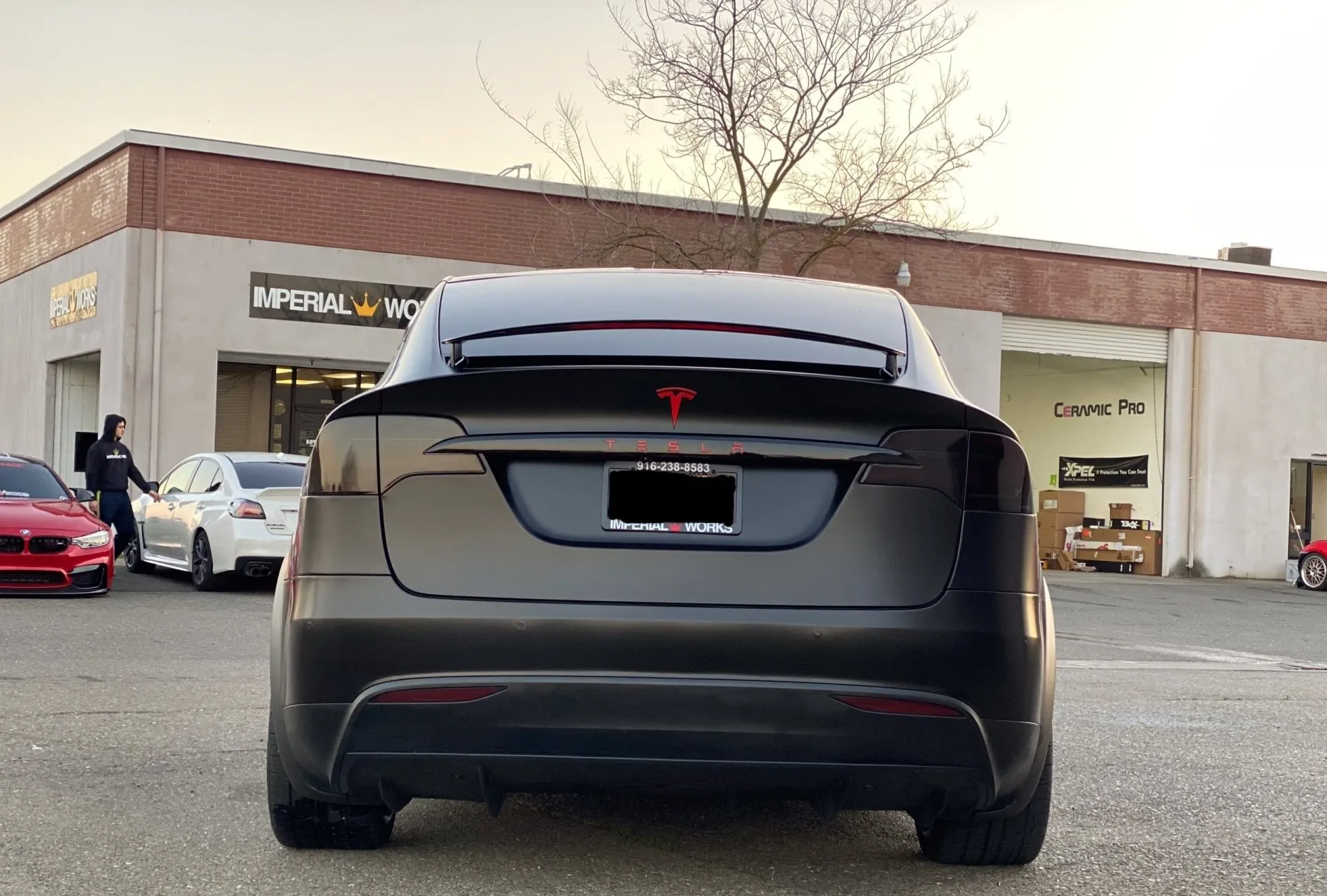 A black tesla model s is parked in front of a building.