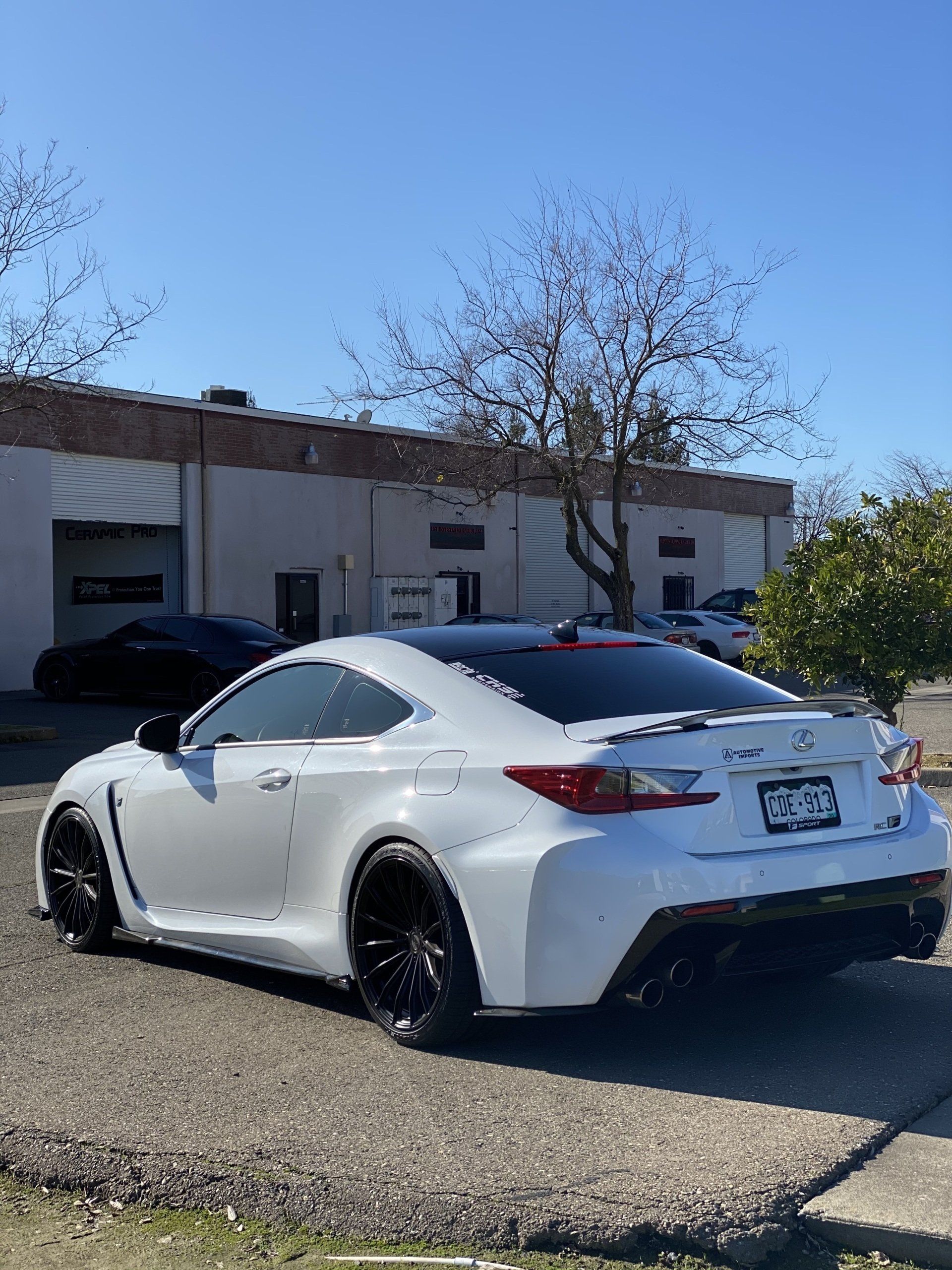 A white sports car is parked in front of a building.