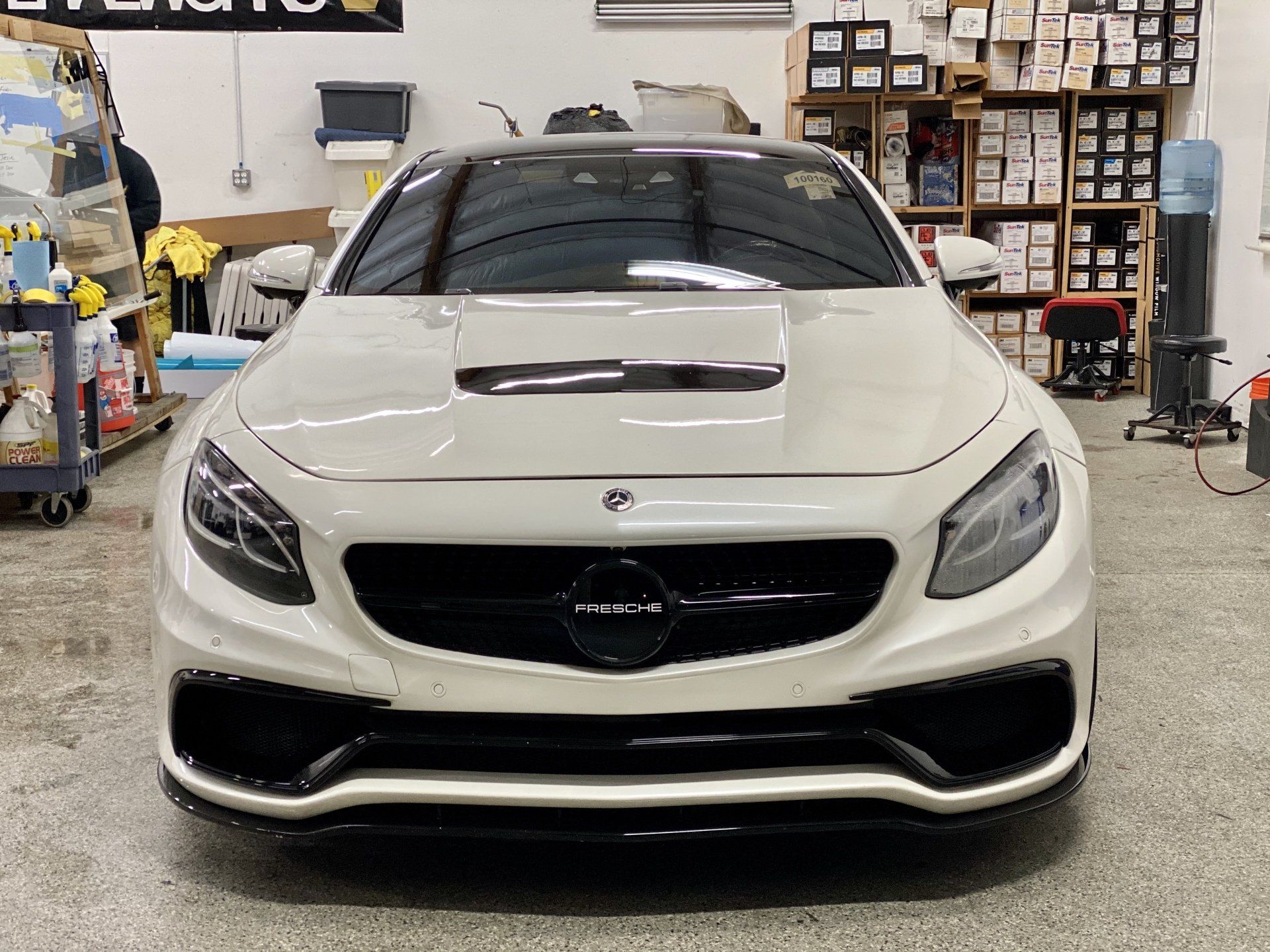 A white mercedes benz s63 amg is parked in a garage.