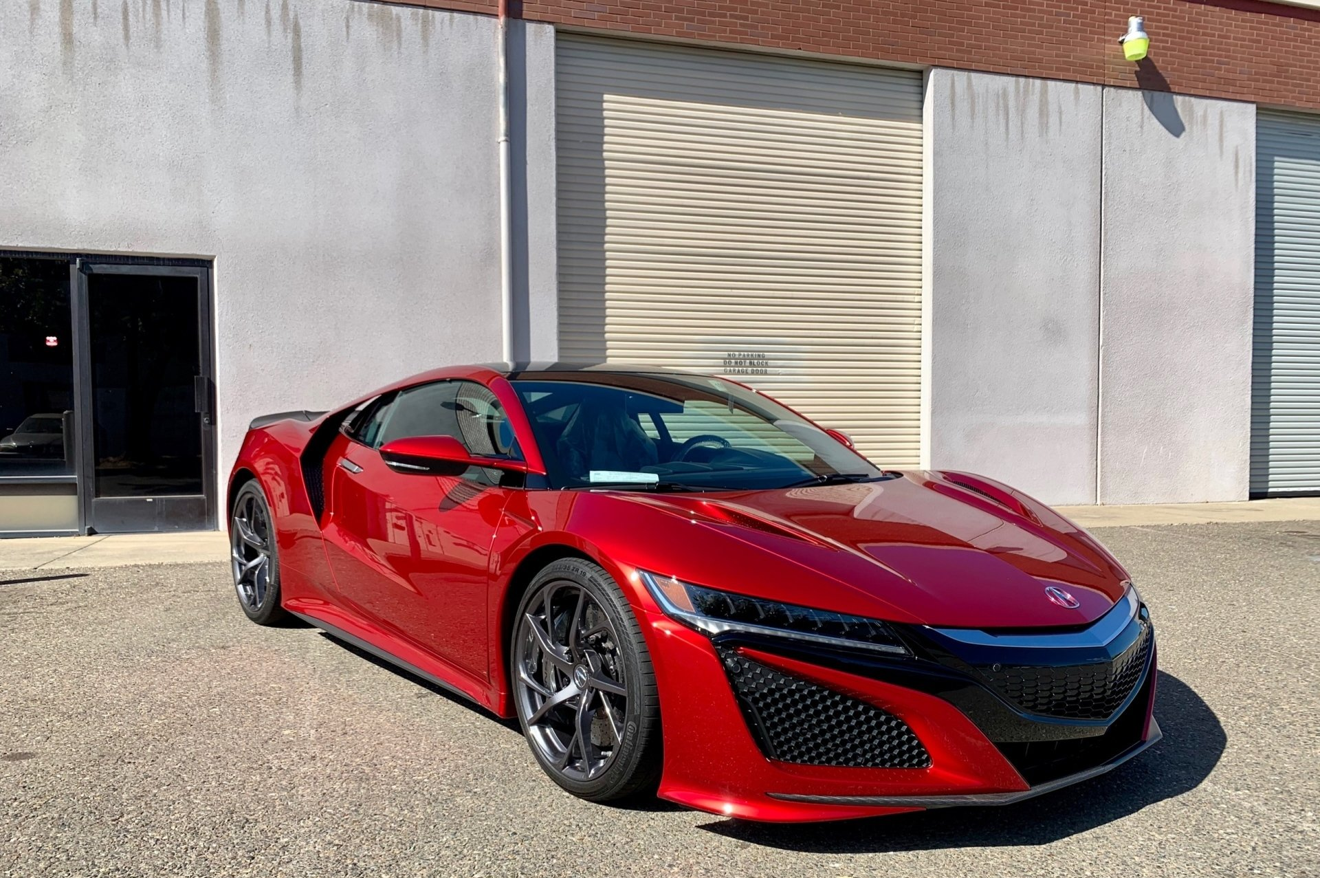 A red sports car is parked in front of a building.