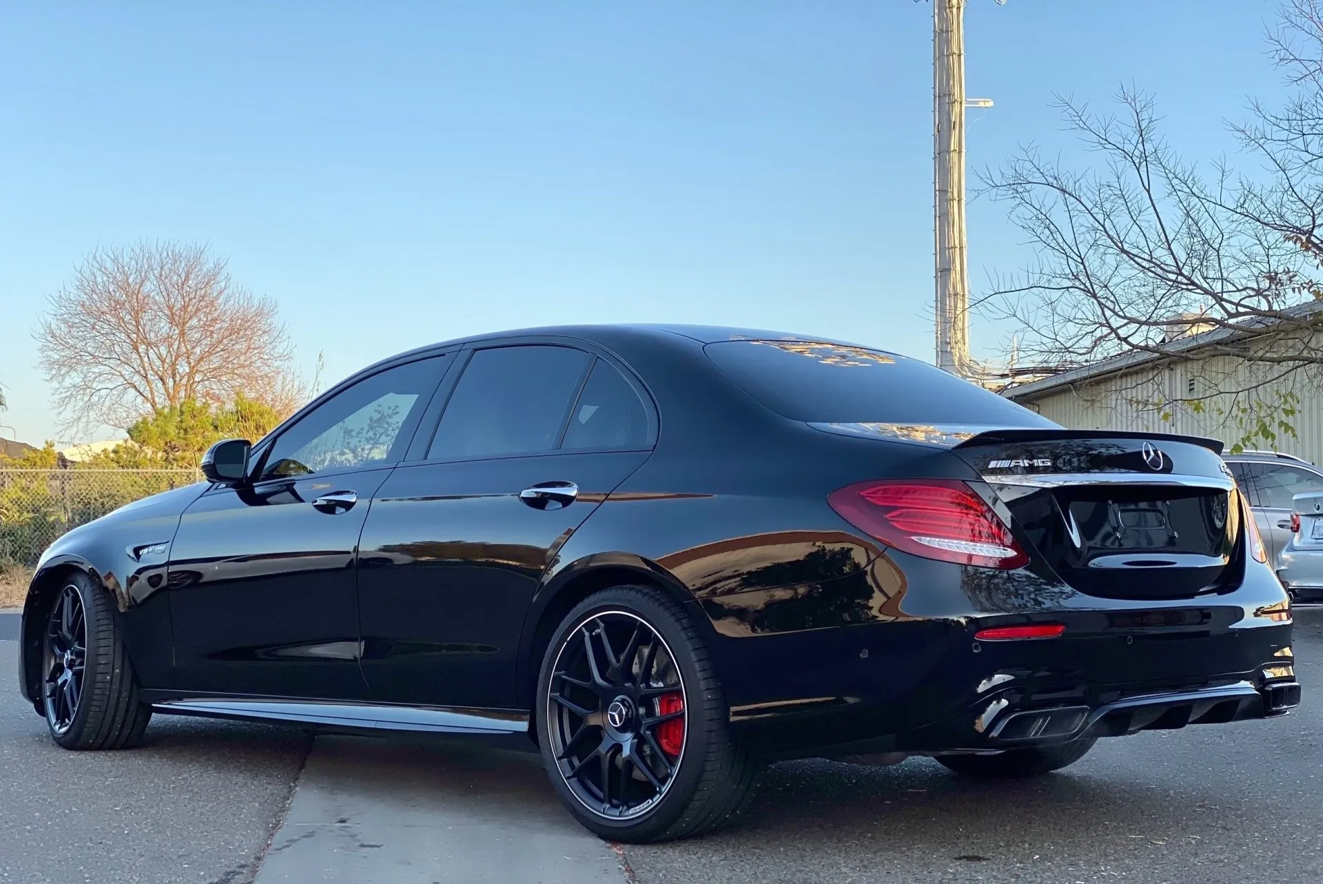 A black mercedes benz is parked on the side of the road.