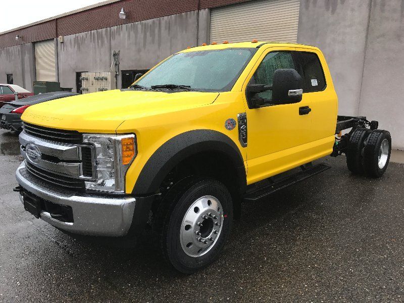 A yellow truck is parked in front of a building.