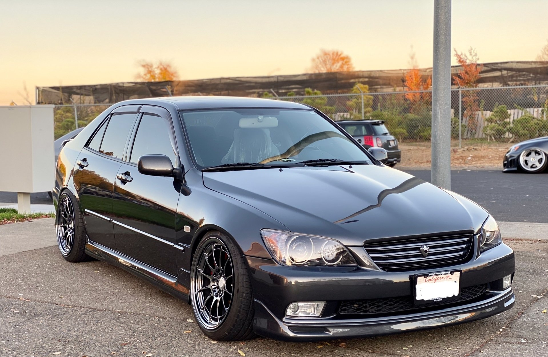 A black car is parked in a parking lot