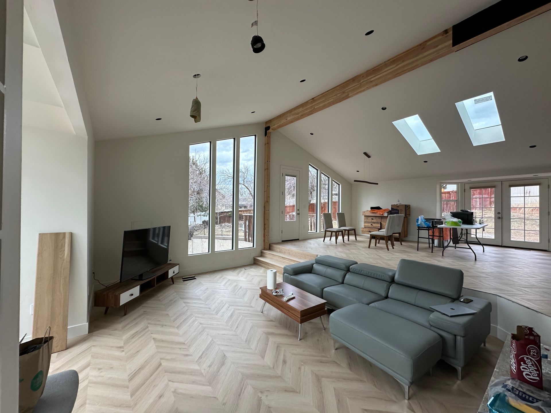 A modern kitchen with a dining table and chairs and a brick wall.