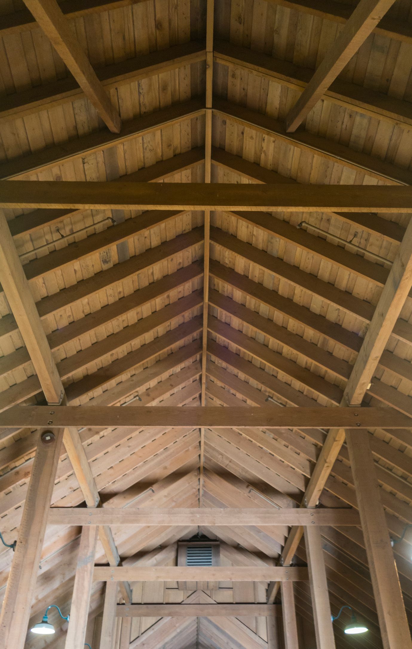 An empty living room with a fireplace and shutters on the windows.