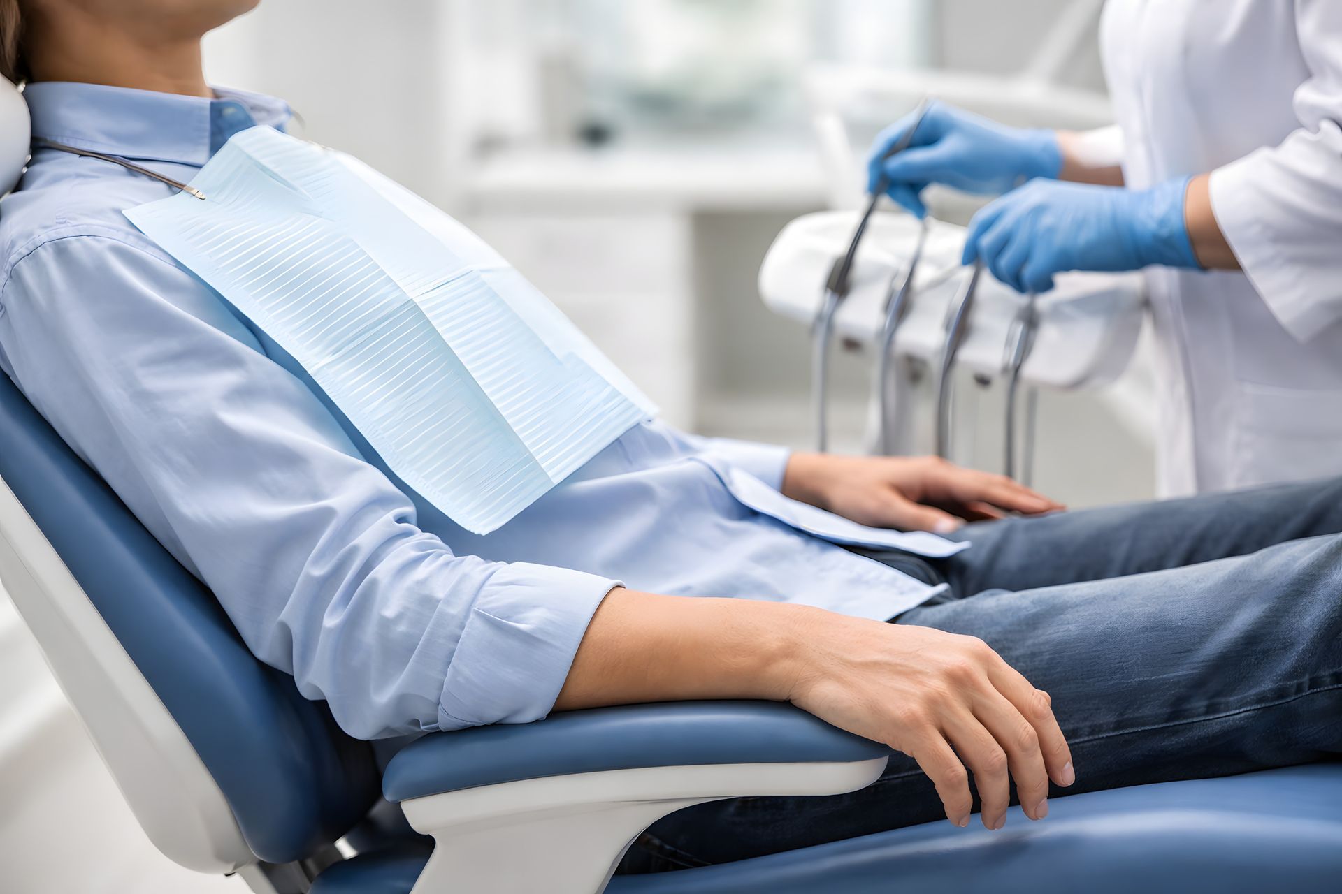 Patient in dental chair during dental visit, face not visible.