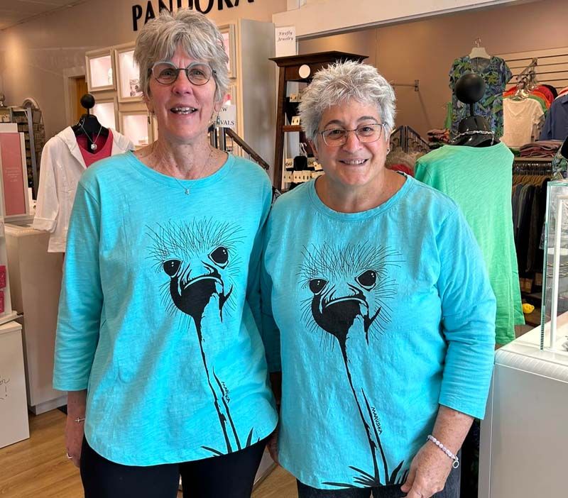 Two women wearing blue shirts with dandelions on them
