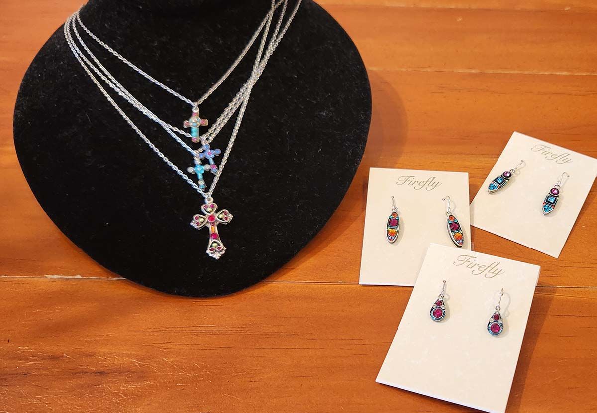 A black mannequin with a necklace and earrings on it