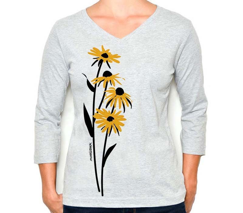 A woman wearing a grey shirt with yellow daisies on it