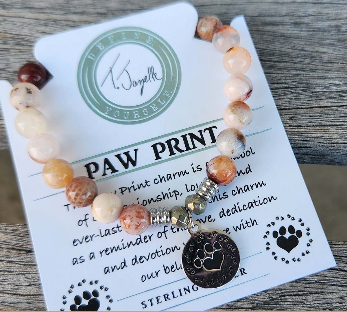 A paw print card with a bracelet on it