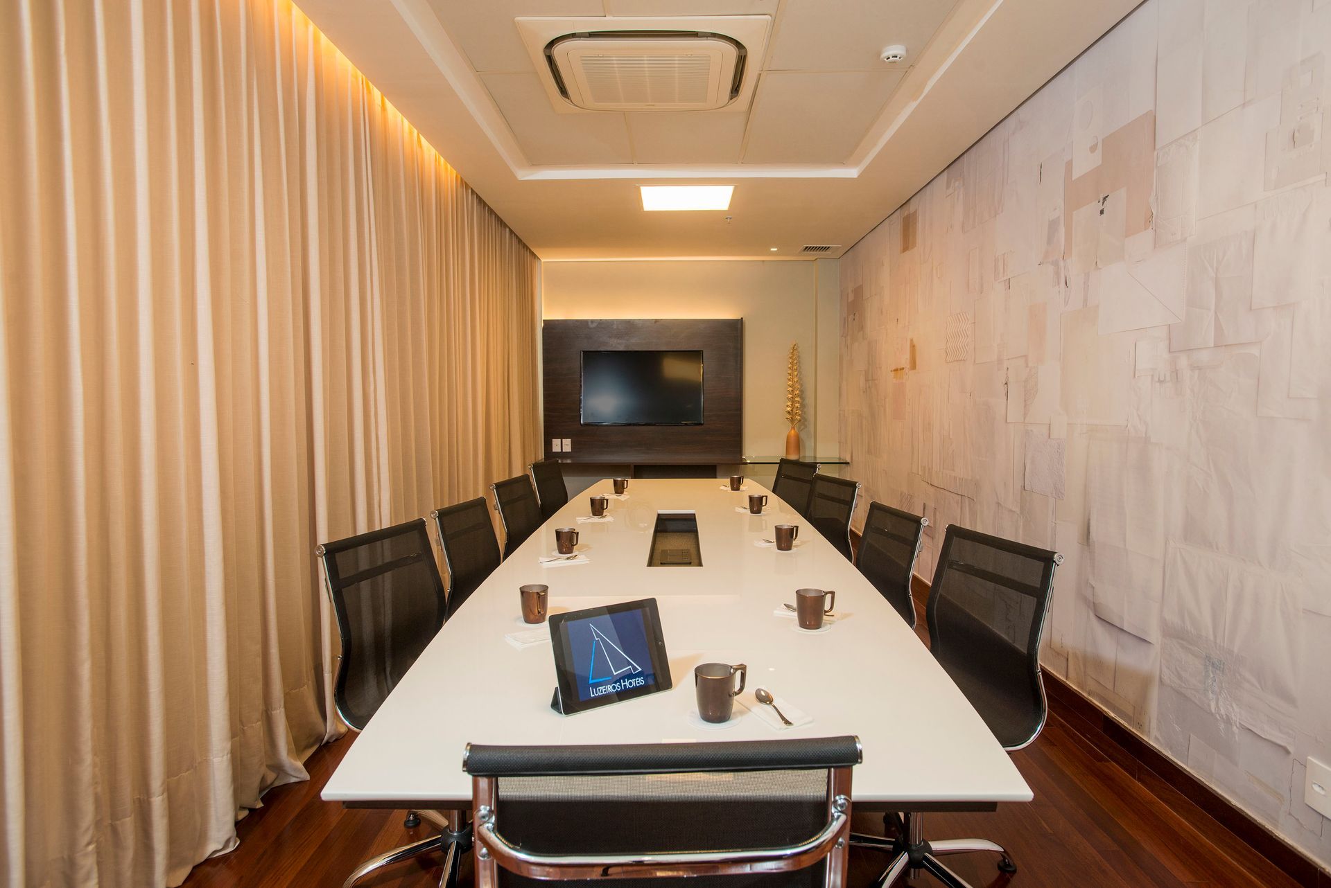 Uma sala de conferências com uma longa mesa e cadeiras.