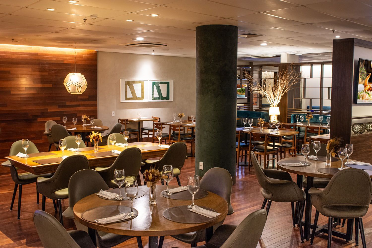 Um restaurante cheio de mesas e cadeiras e taças de vinho.
