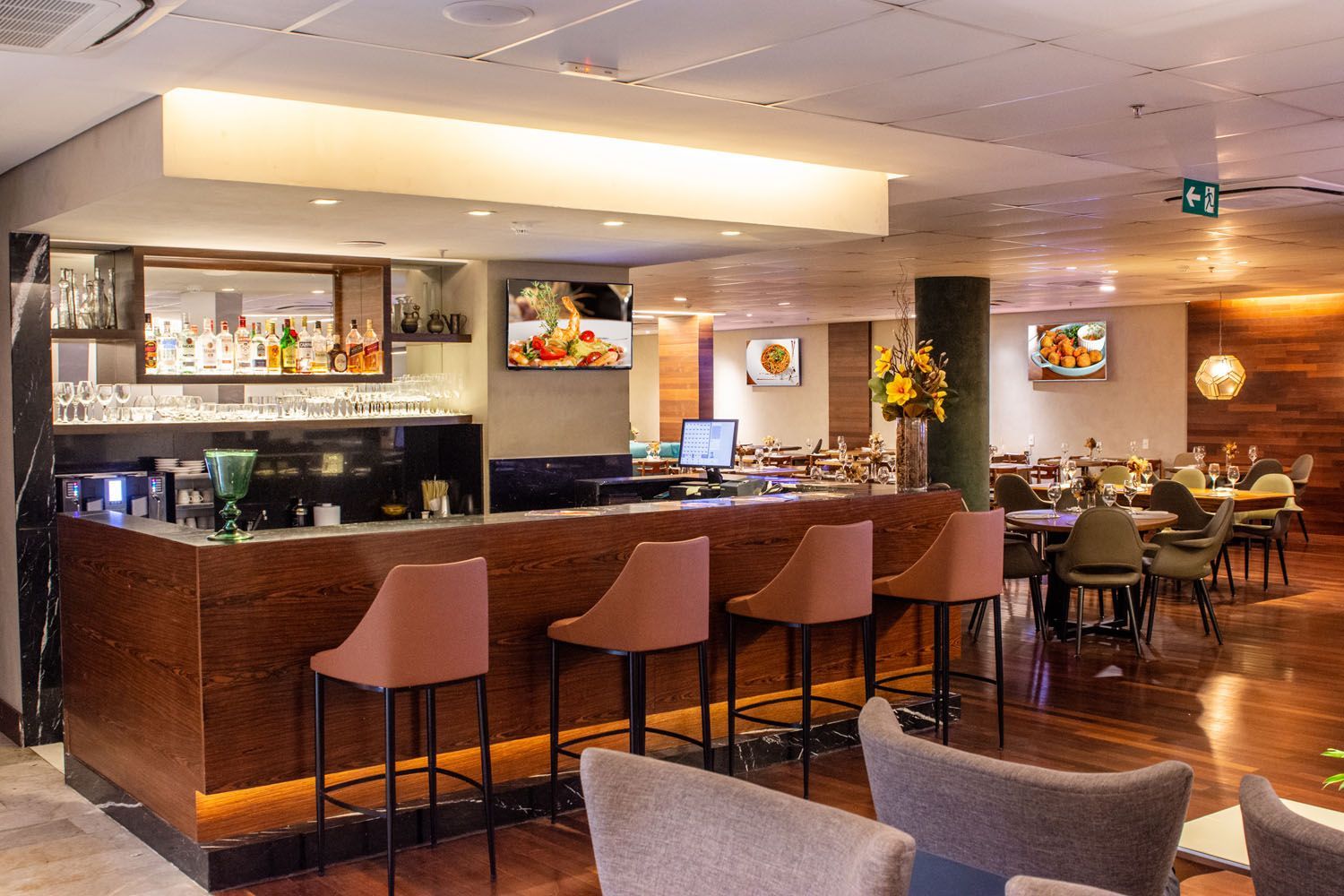 Um restaurante com bar e cadeiras no meio da sala.