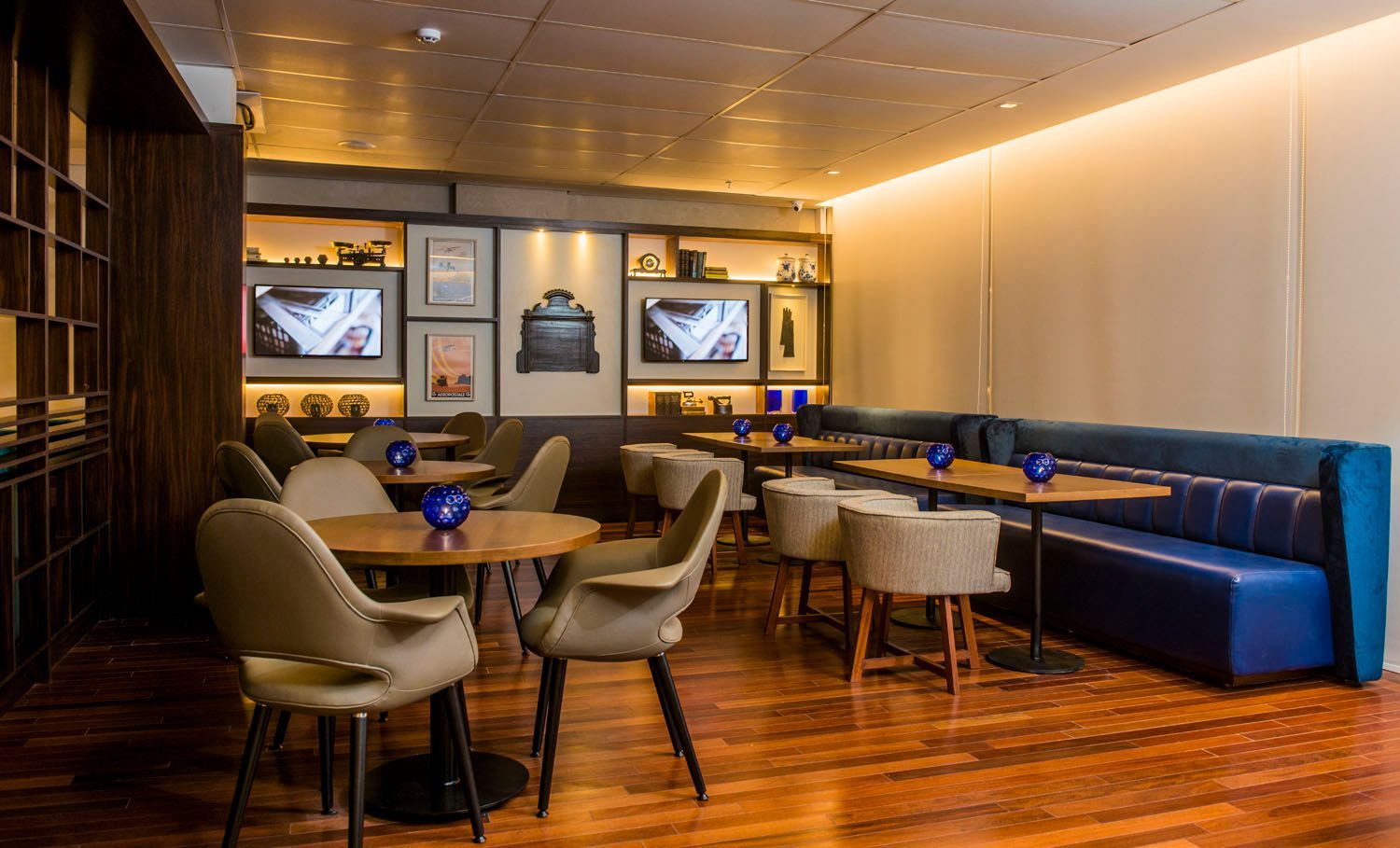 Um restaurante com mesas e cadeiras e um sofá azul.