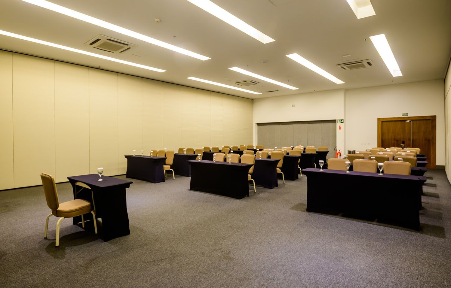 Uma grande sala com mesas e cadeiras