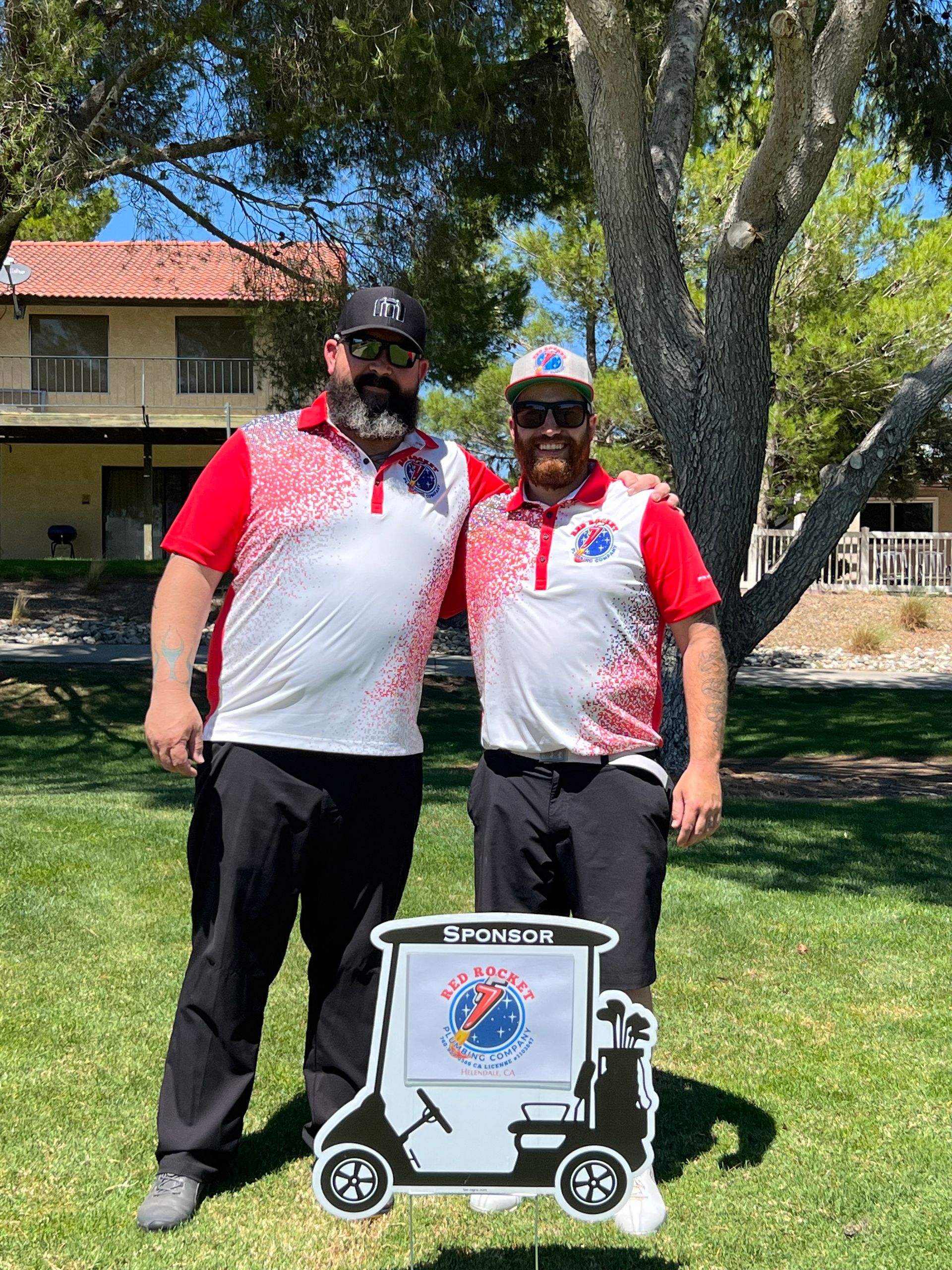 Two men are standing next to each other in front of a golf cart.