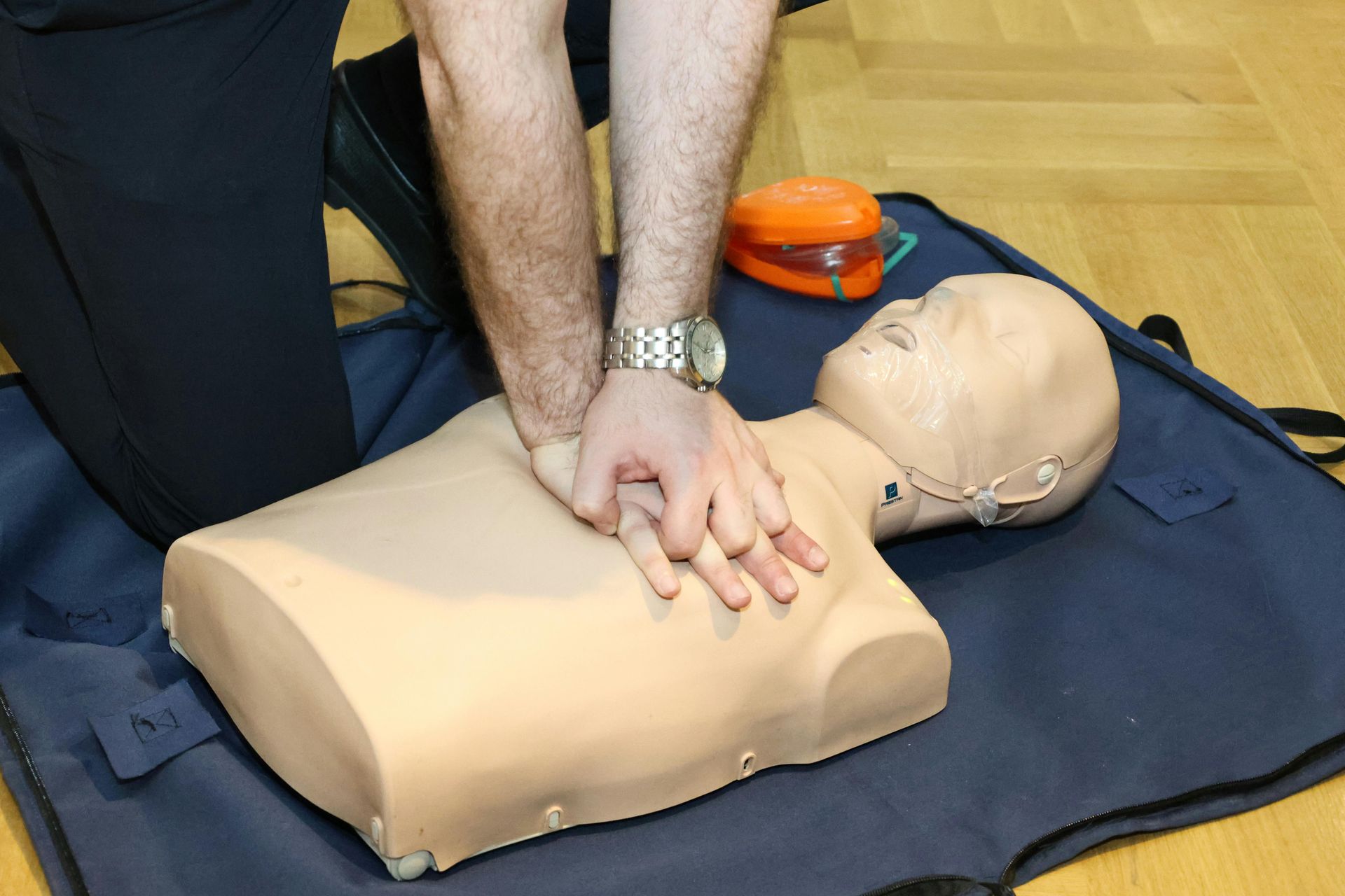Person performing CPR on a training mannequin.