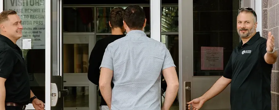 A group of men are standing in front of a door.