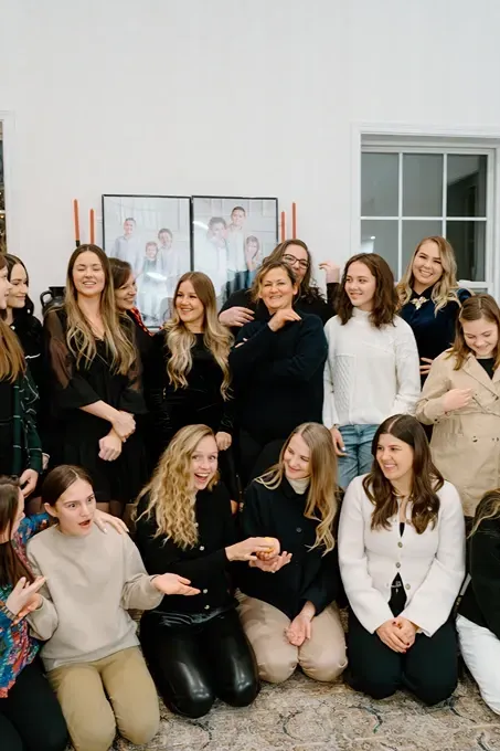 A group of women are posing for a picture together in a living room.