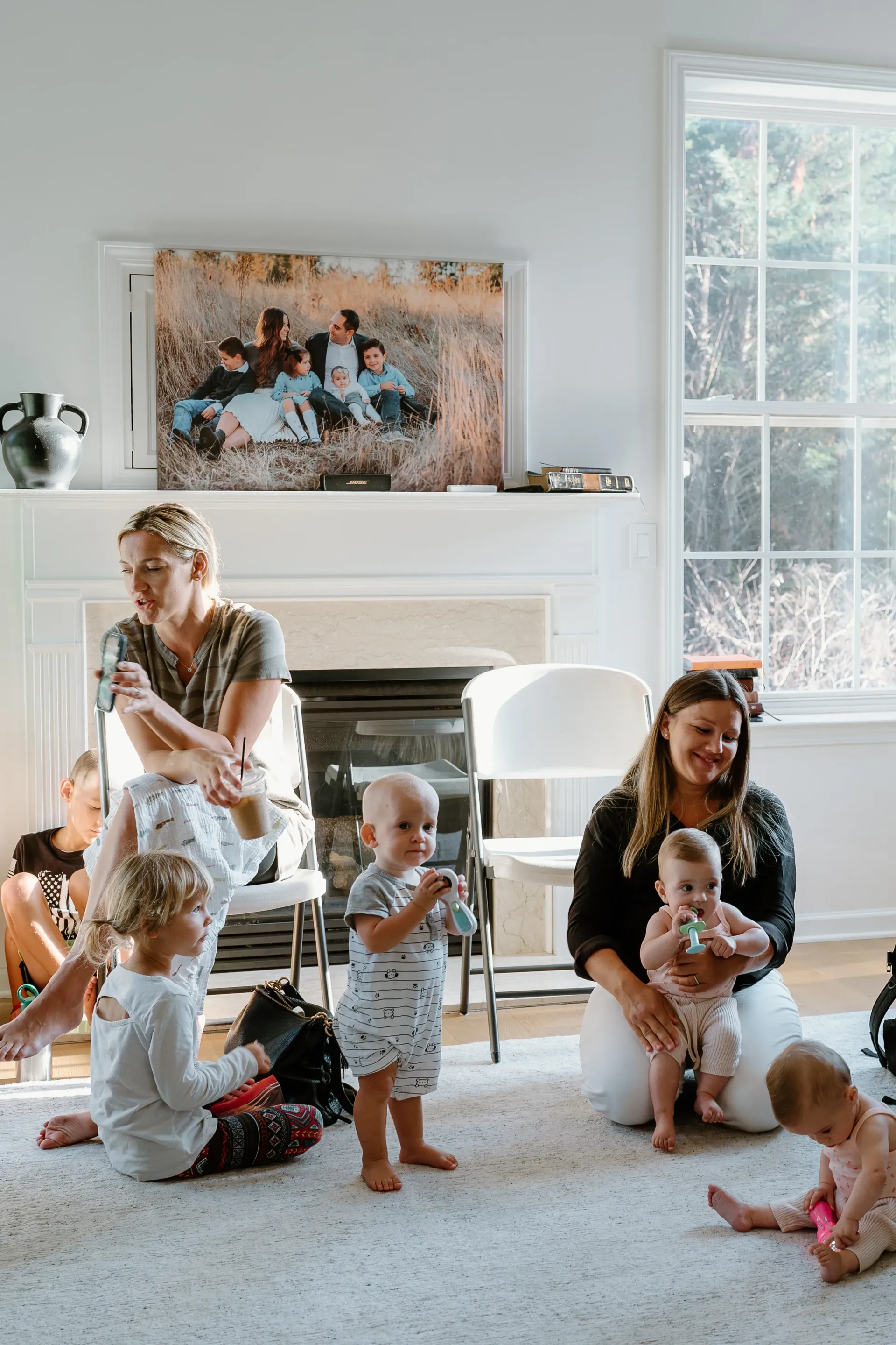 A group of women are playing with babies in a living room.