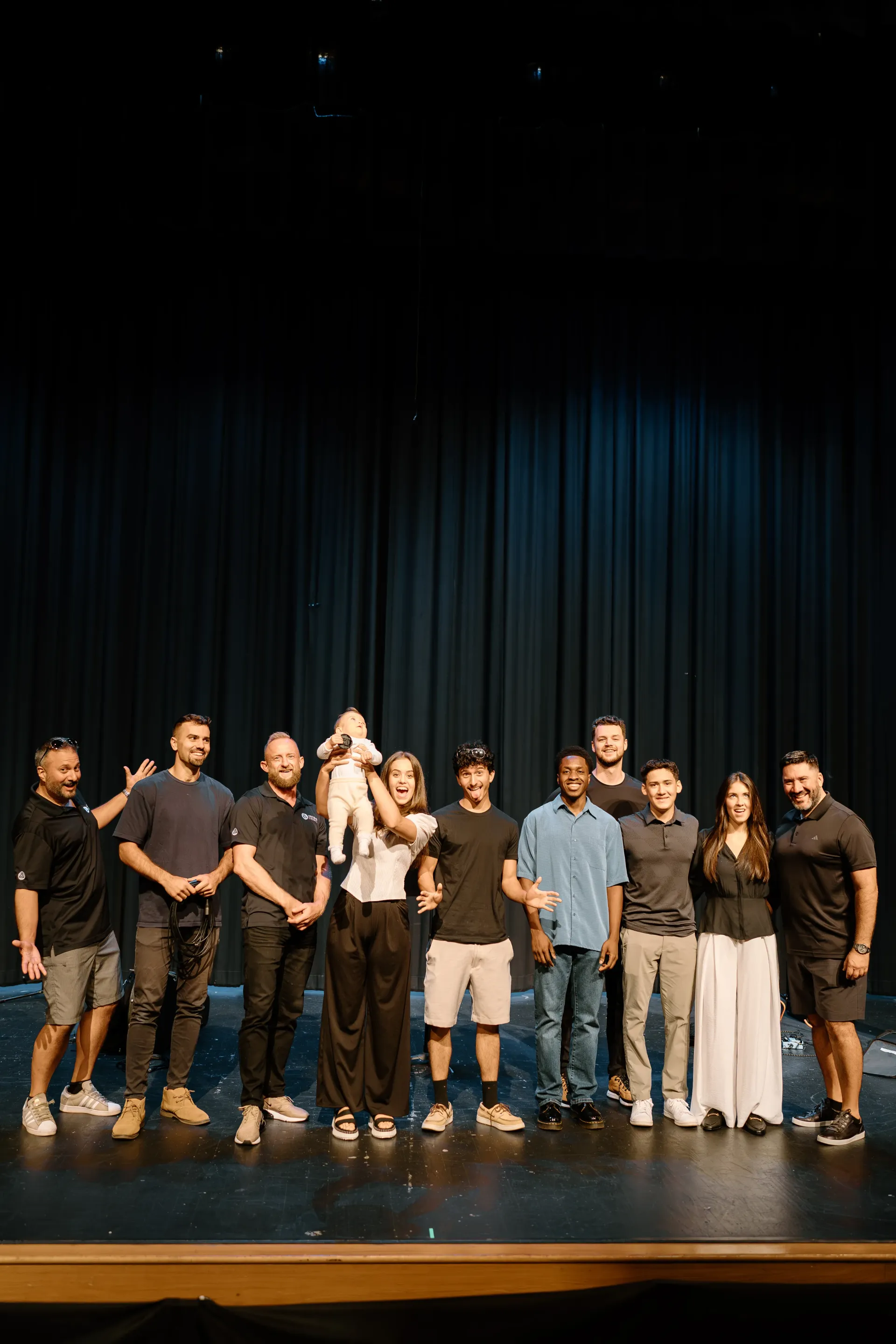 A group of people are posing for a picture on a stage.