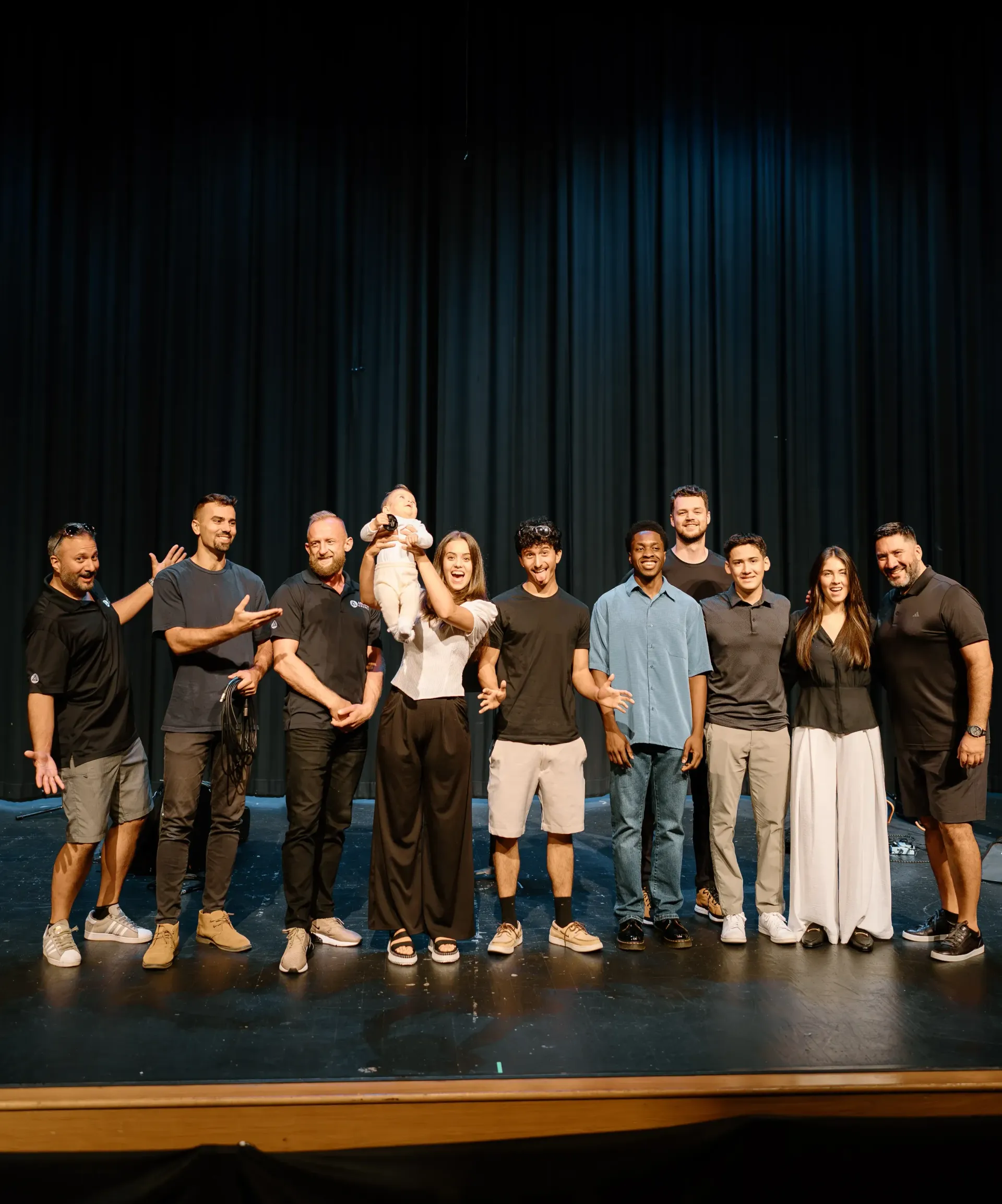 A group of people are posing for a picture on a stage.