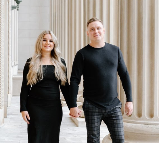 A man and a woman are standing next to each other holding hands